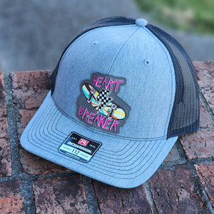 Grey cap with patches on a brick surface