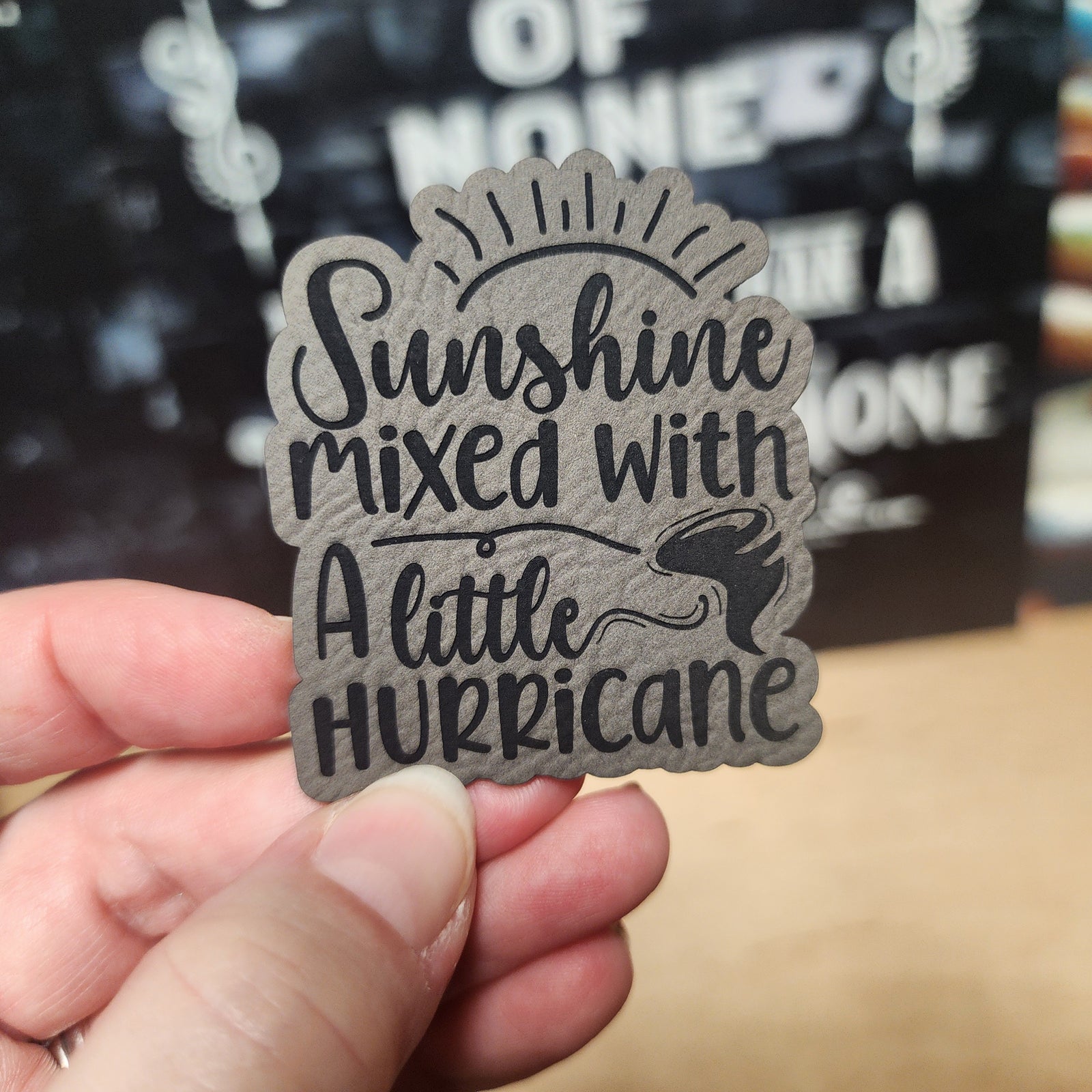 Leatherette hat patch featuring 'Sunshine mixed with a little Hurricane' design, perfect for trendy headwear.