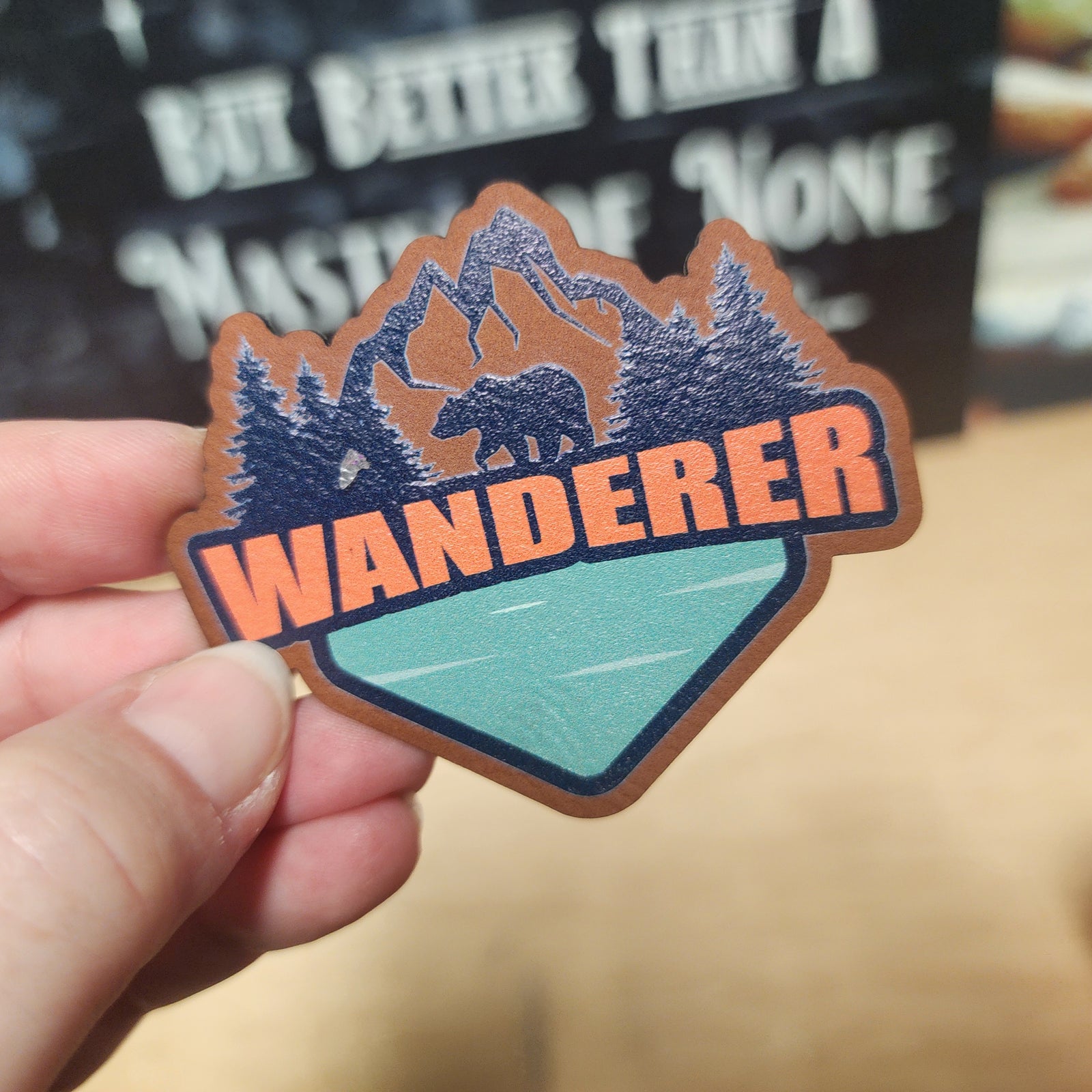 Wanderer outdoor leatherette hat patch featuring mountains, trees, and a bear, perfect for adventure lovers.