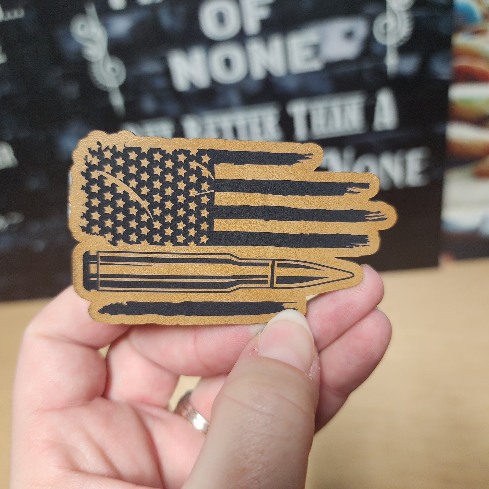 American flag leatherette hat patch with bullet design, perfect for patriotic apparel and outdoor gear enthusiasts.