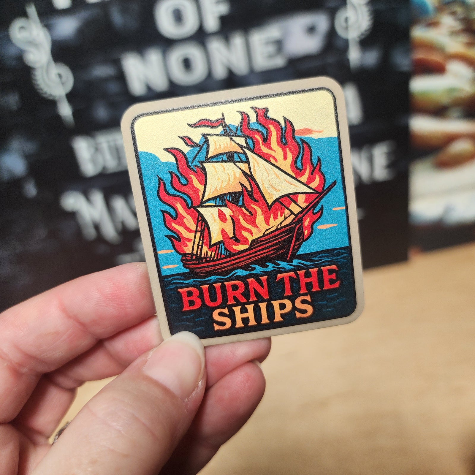 Burn the Ships leatherette hat patch, nautical artwork, vibrant ship design for adventure lovers and hat collectors.