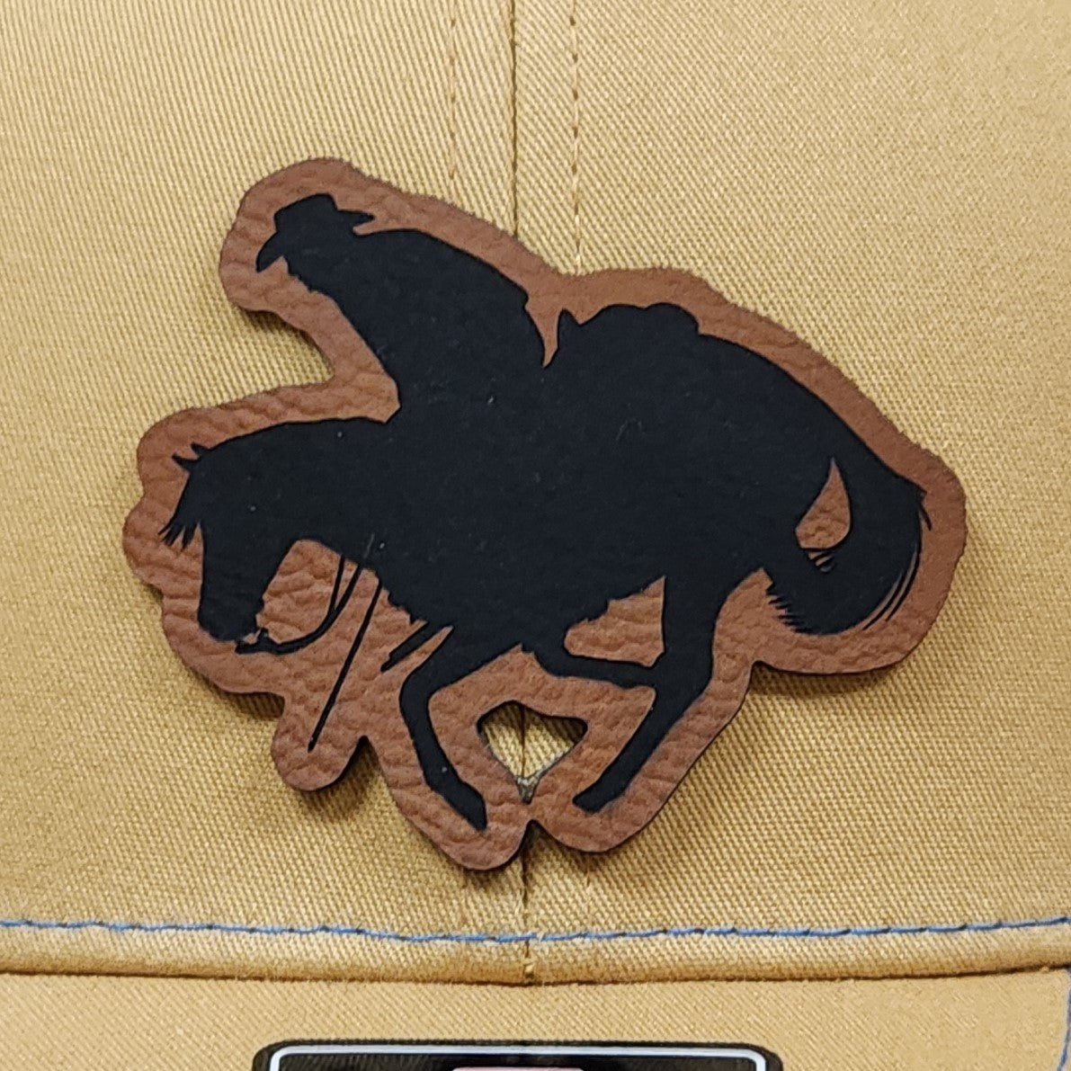 Rodeo leatherette hat patch featuring a cowboy riding a horse for Western themed headwear.