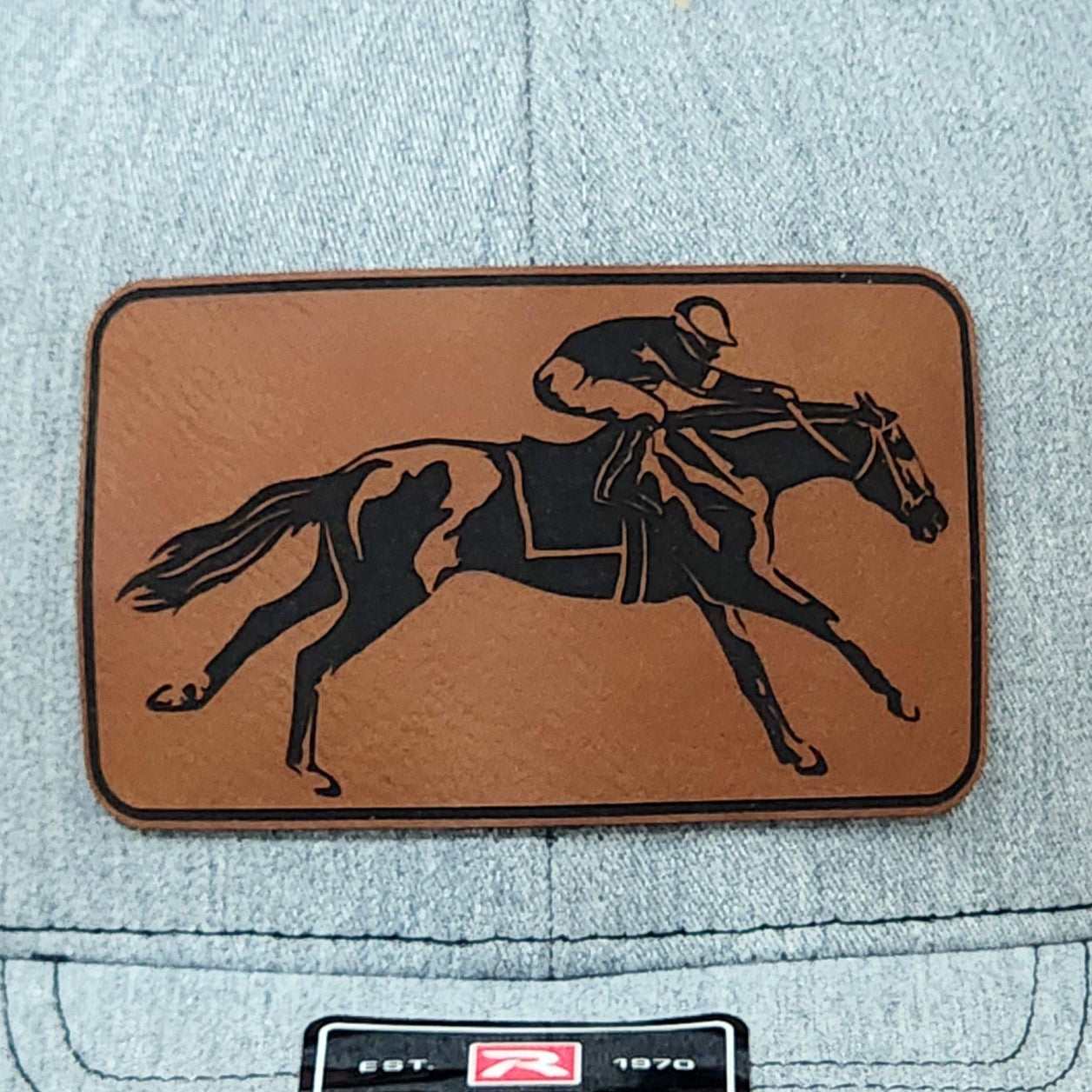 Horse racing leatherette hat patch, perfect for equestrian enthusiasts and stylish outdoor wear.