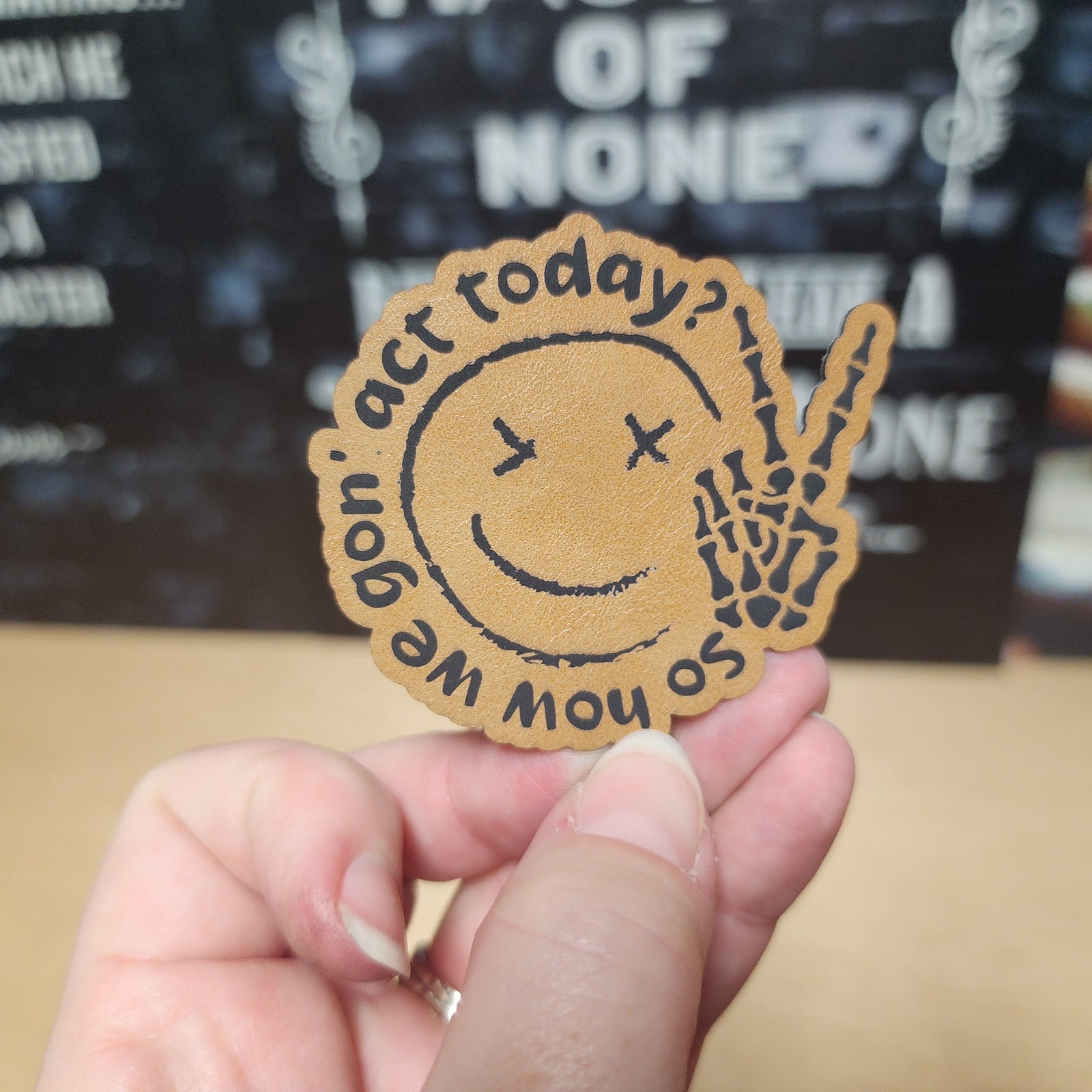Leatherette smiley face patch with skeleton hand, perfect for creative DIY projects and accessories.