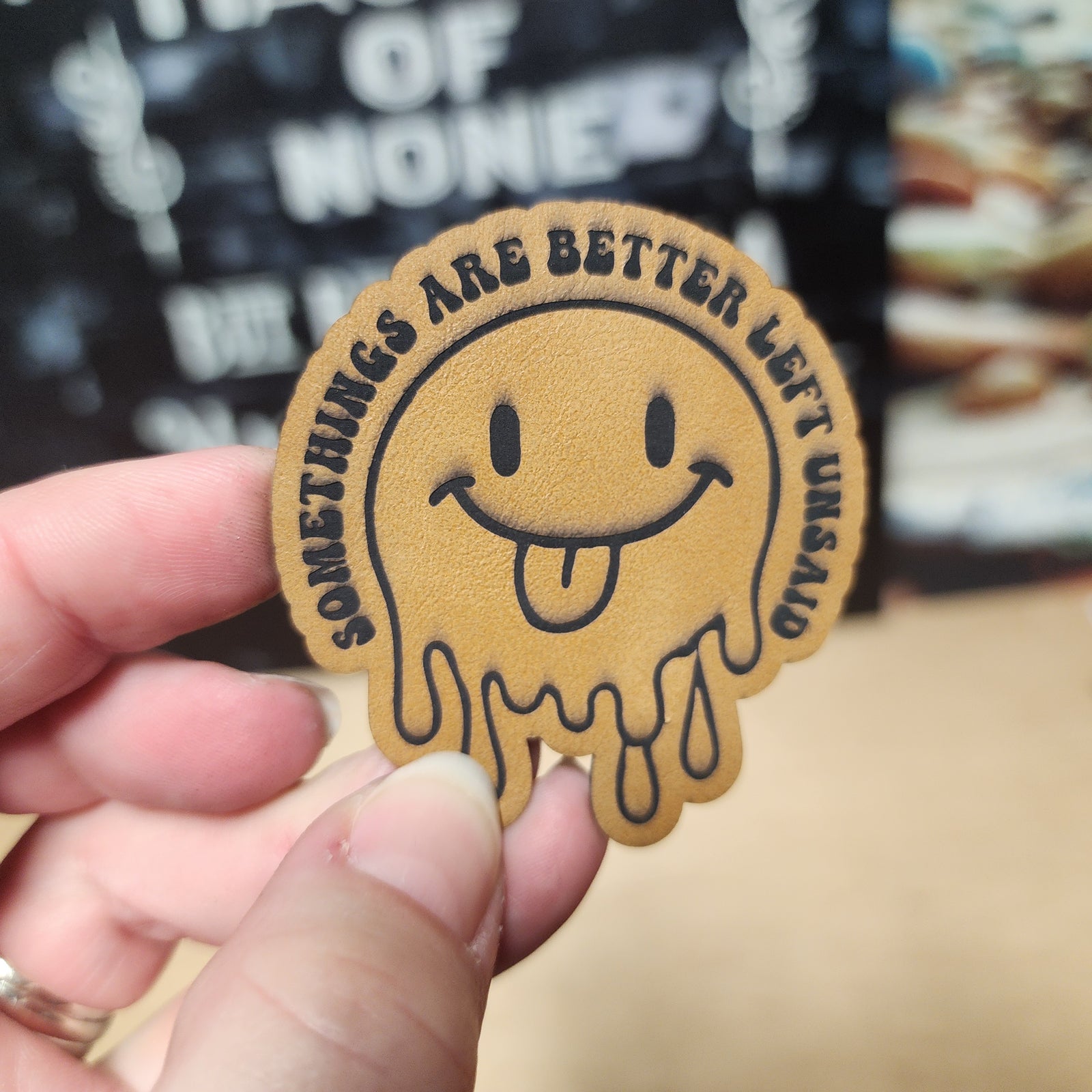 Funny leatherette hat patch with a smiling face and the phrase 'Some things are better left unsaid'
