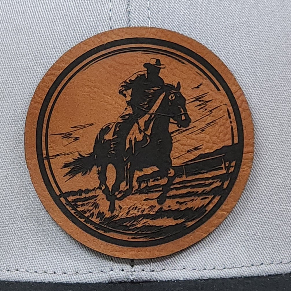 Cowboy leatherette hat patch featuring a rider on horseback, perfect for Western-themed apparel and accessories.