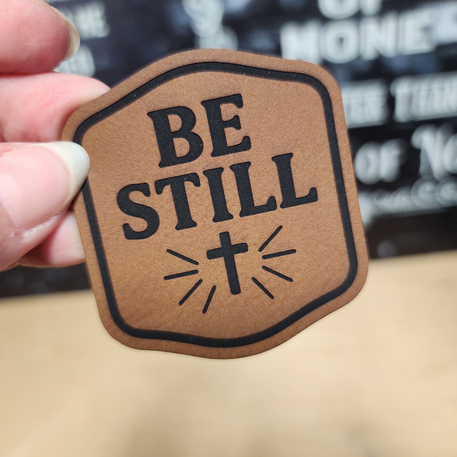 Be Still leatherette hat patch with cross and rays, perfect for Christian apparel or accessories.