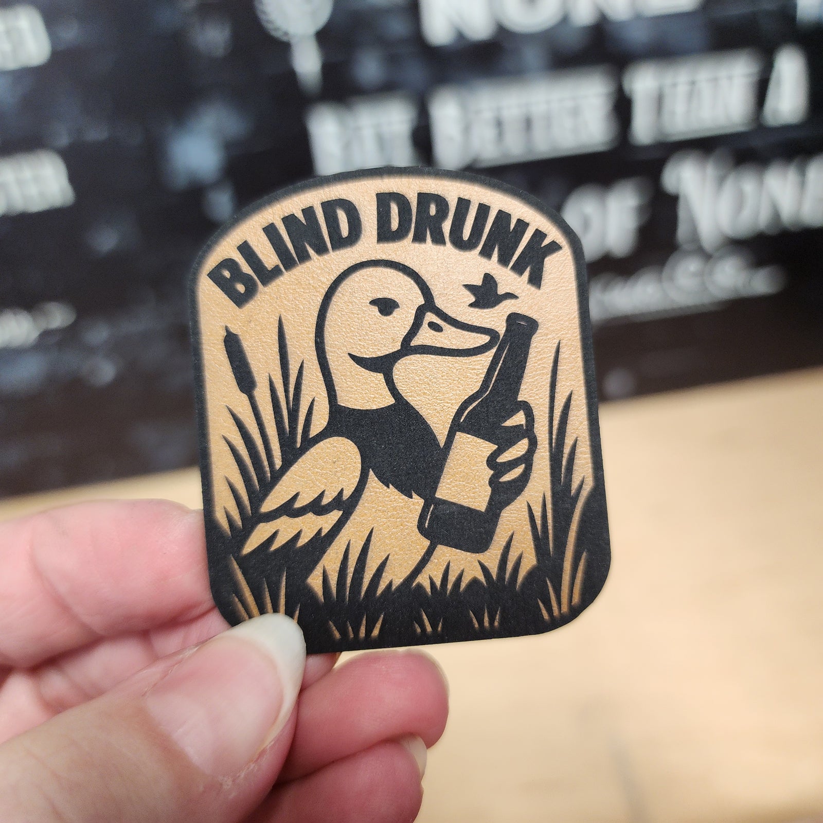Blind Drunk leatherette hat patch featuring a duck holding a beer bottle, perfect for casual and humorous apparel.