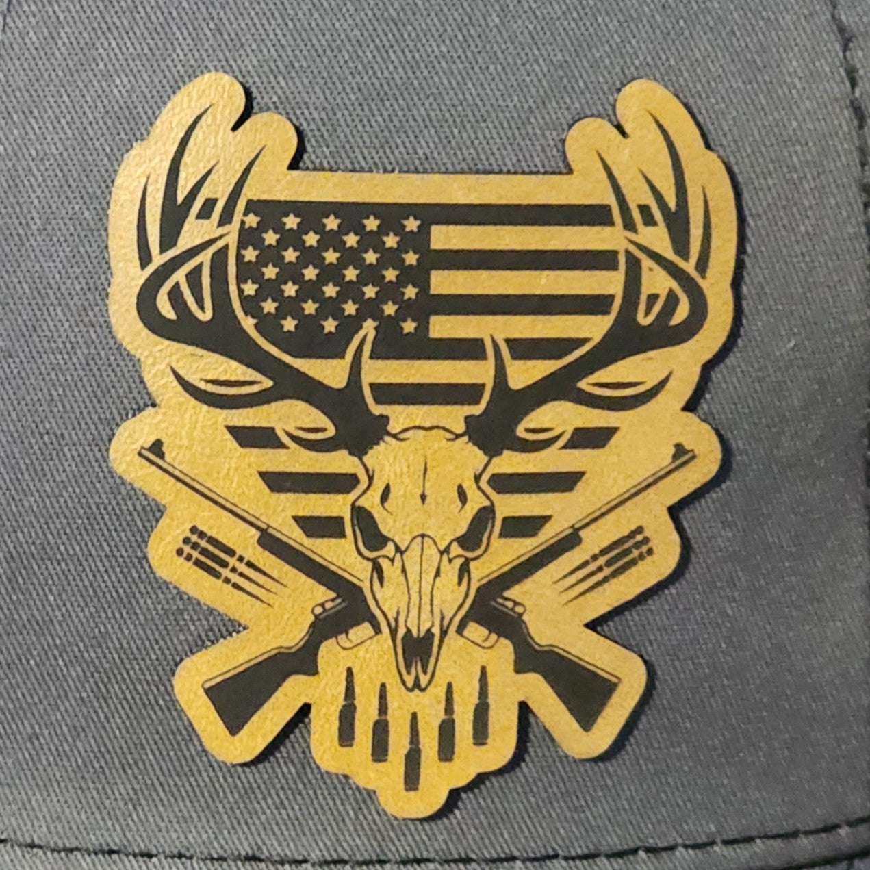 Hunting themed leatherette patch featuring deer skull, American flag, and crossed rifles for outdoor enthusiasts.