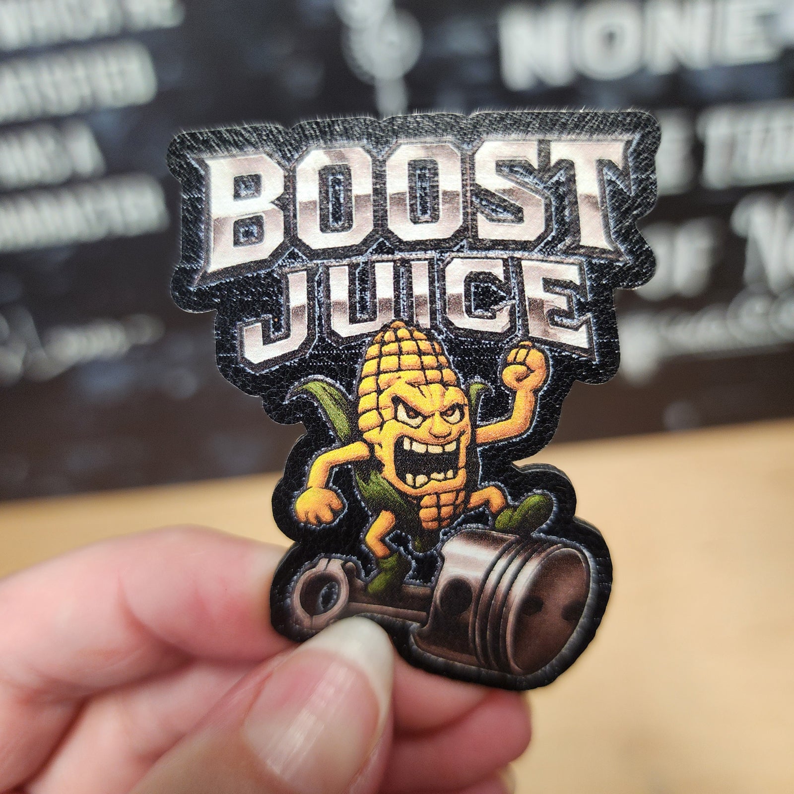 Boost Juice leatherette hat patch featuring a punk corn character, perfect for automotive enthusiasts.