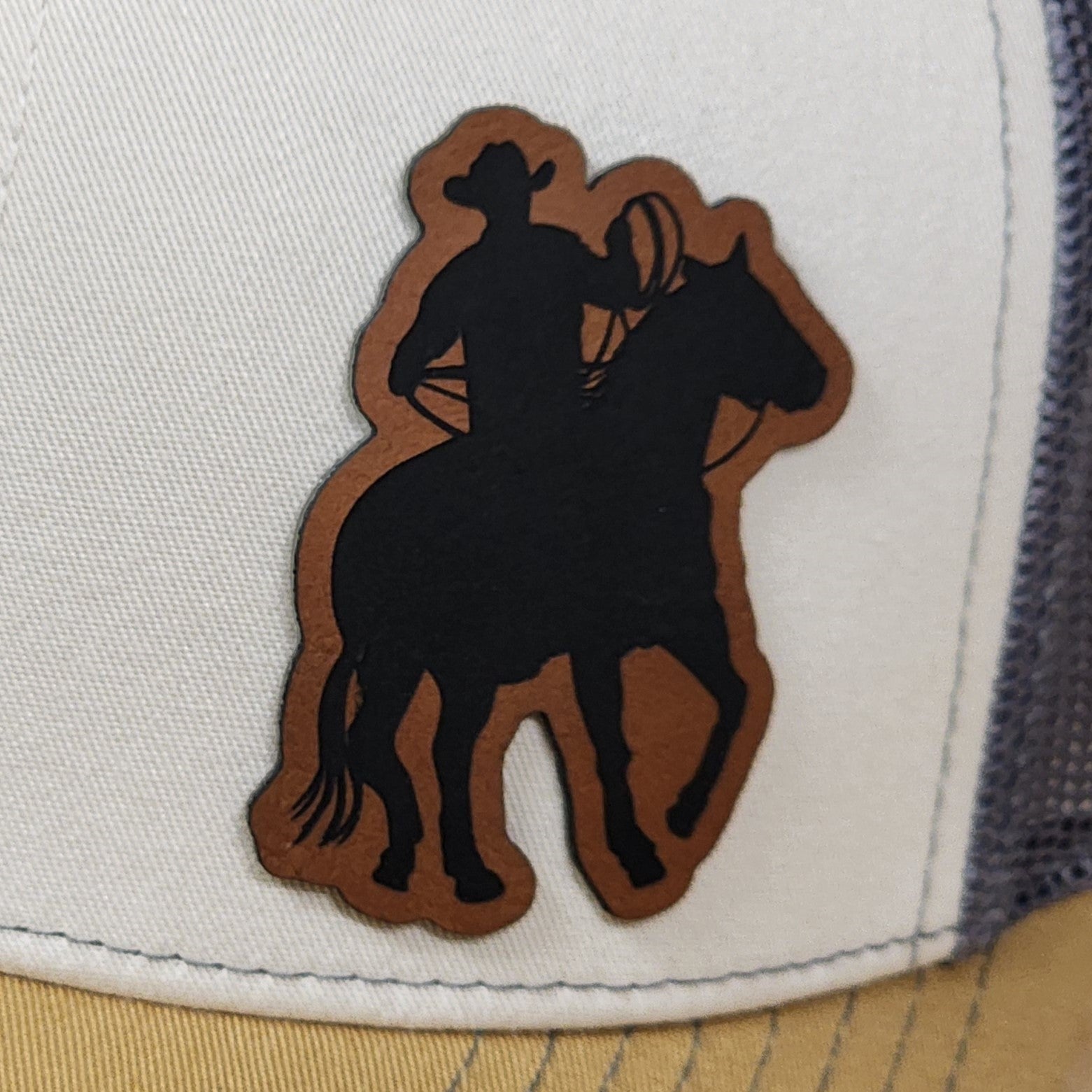 Cowboy hat patch featuring a cowboy on horseback, perfect for western-themed accessories and apparel.