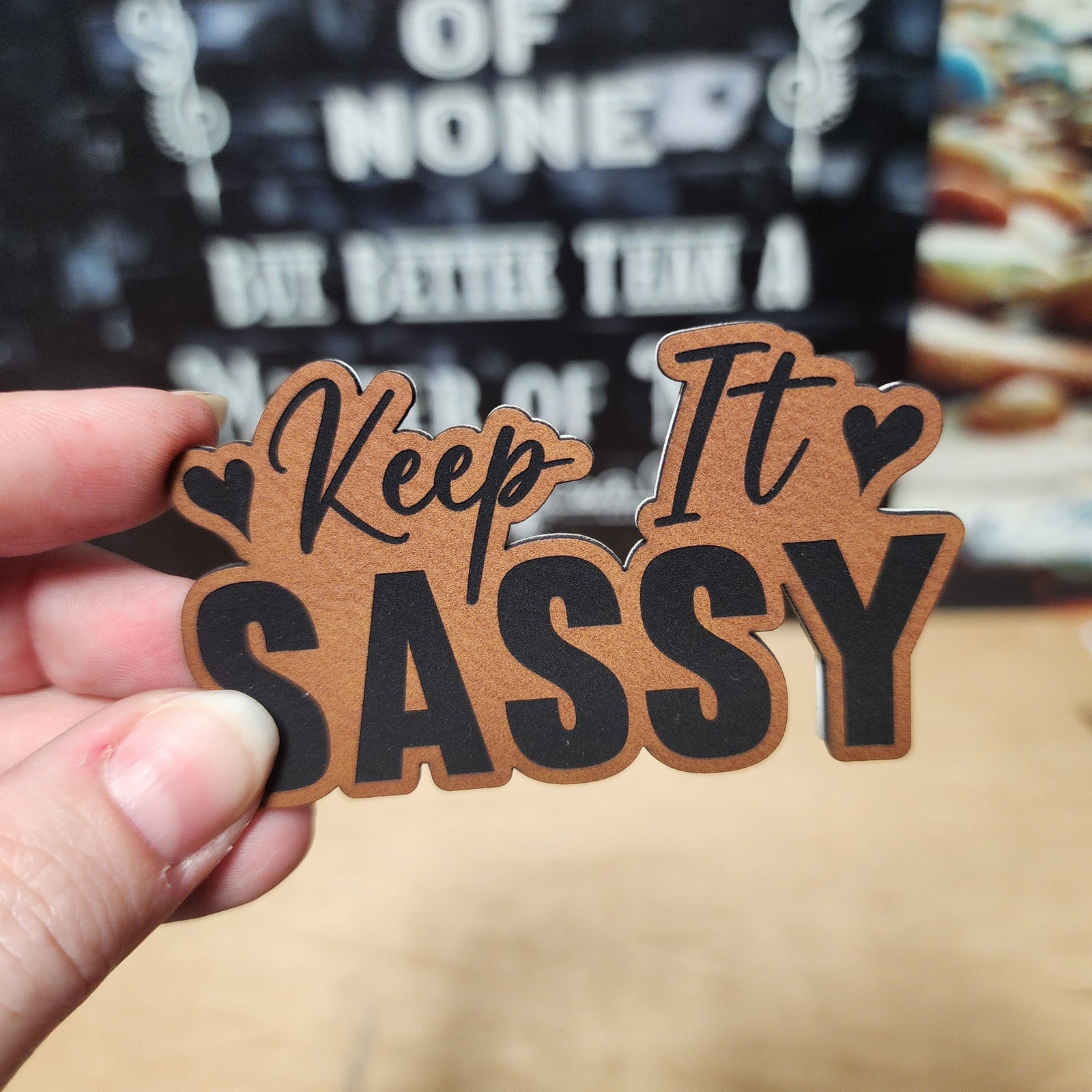 Sassy leatherette hat patch featuring 'Keep It Sassy' in stylish lettering for trendy accessories.