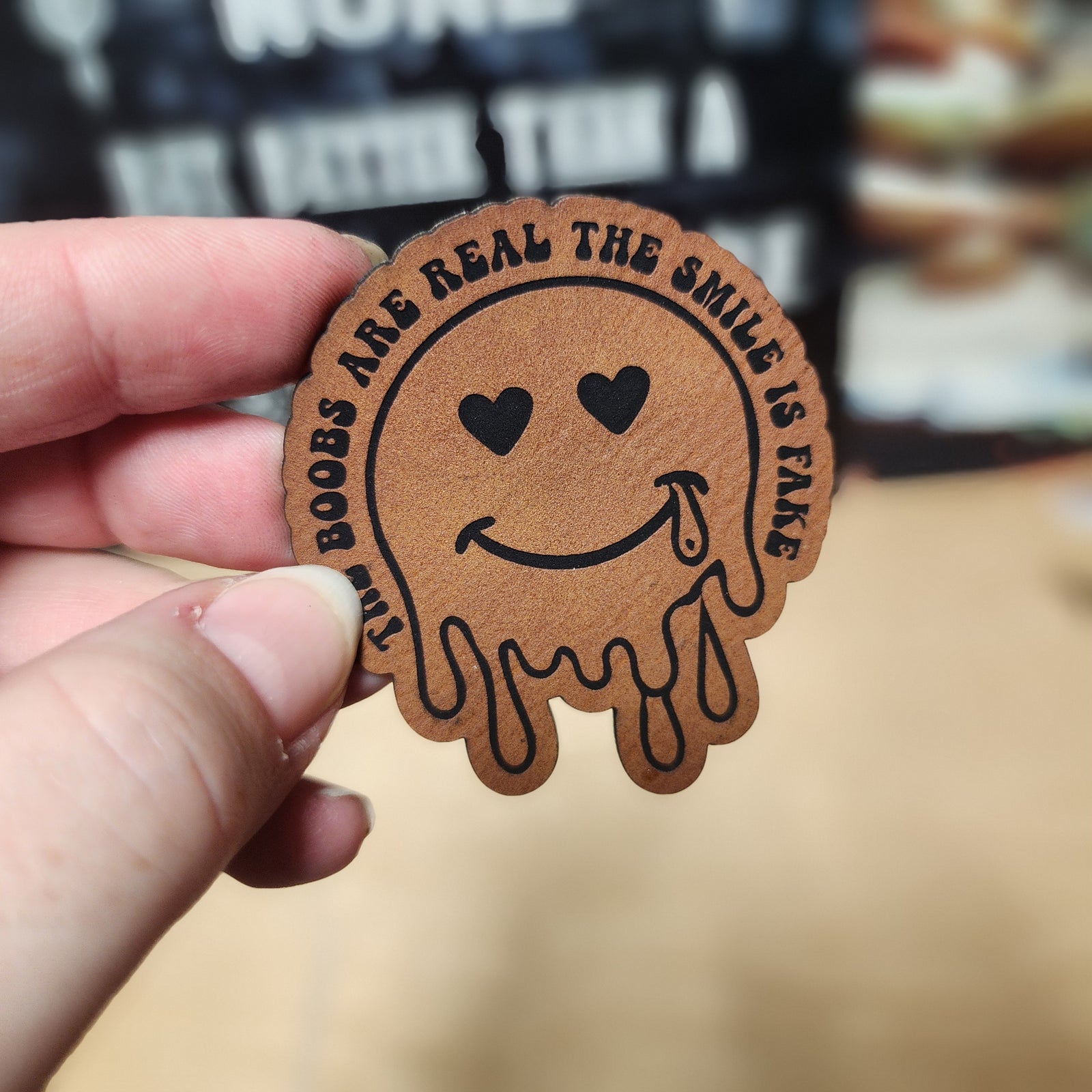 Funny leatherette hat patch with smiling face and quirky text, ideal for unique hat accessories.