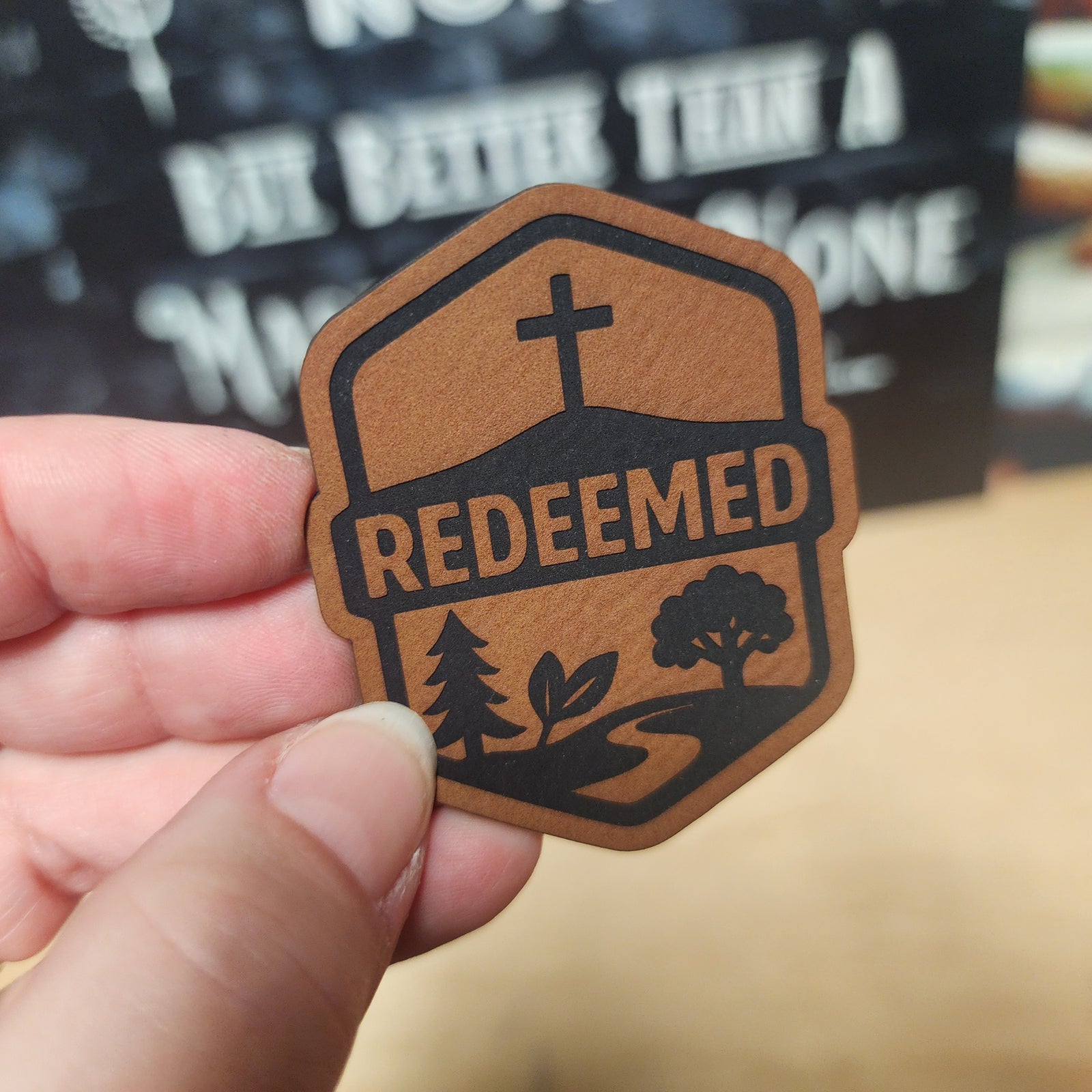 Redeemed leatherette hat patch featuring a cross, trees, and a scenic pathway for faith-based accessories.