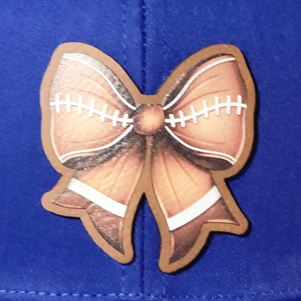 Football leatherette hat patch with bow design, perfect for sports fans and casual wear.