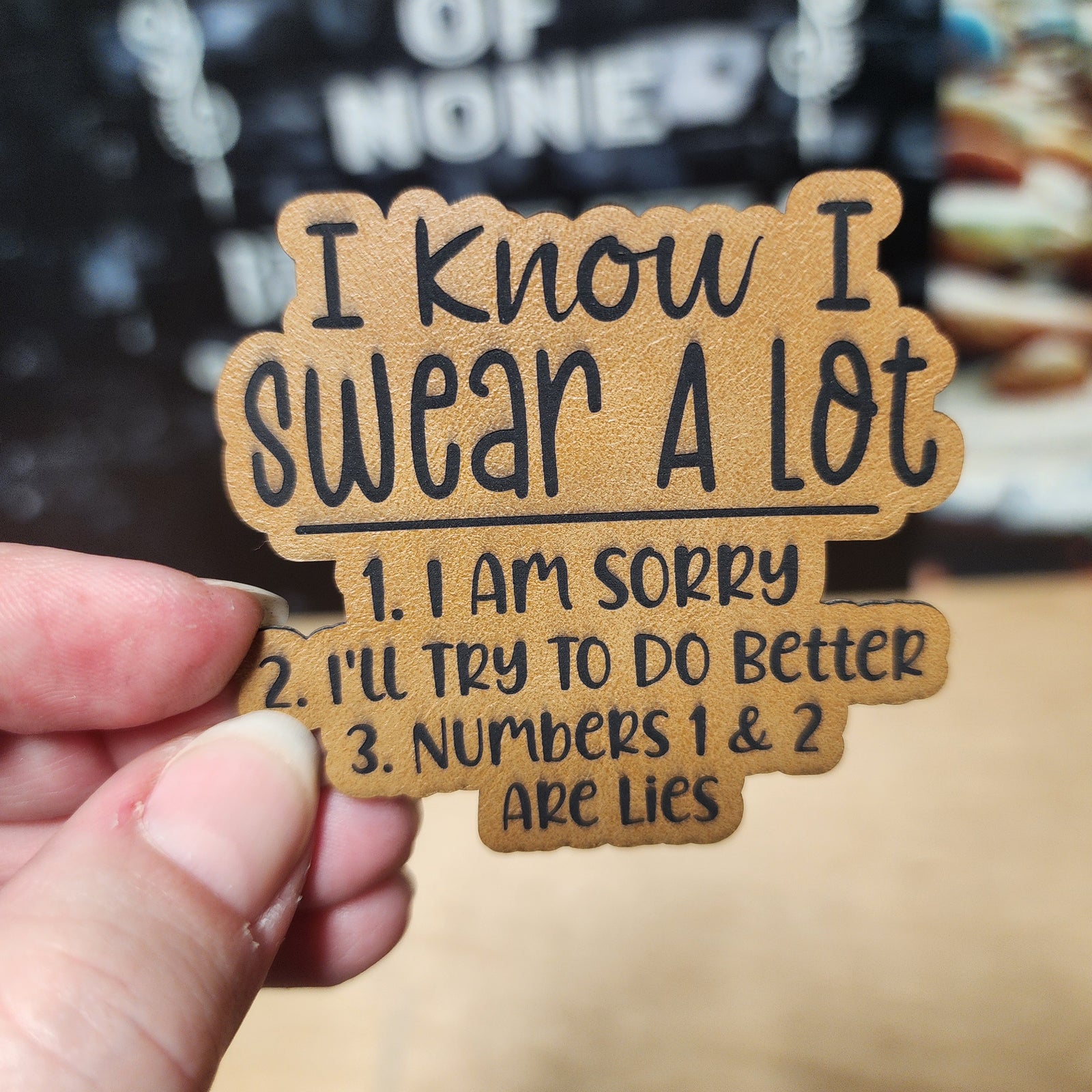 Funny leatherette hat patch saying 'I know I swear a lot' with humorous apologies for swearing.