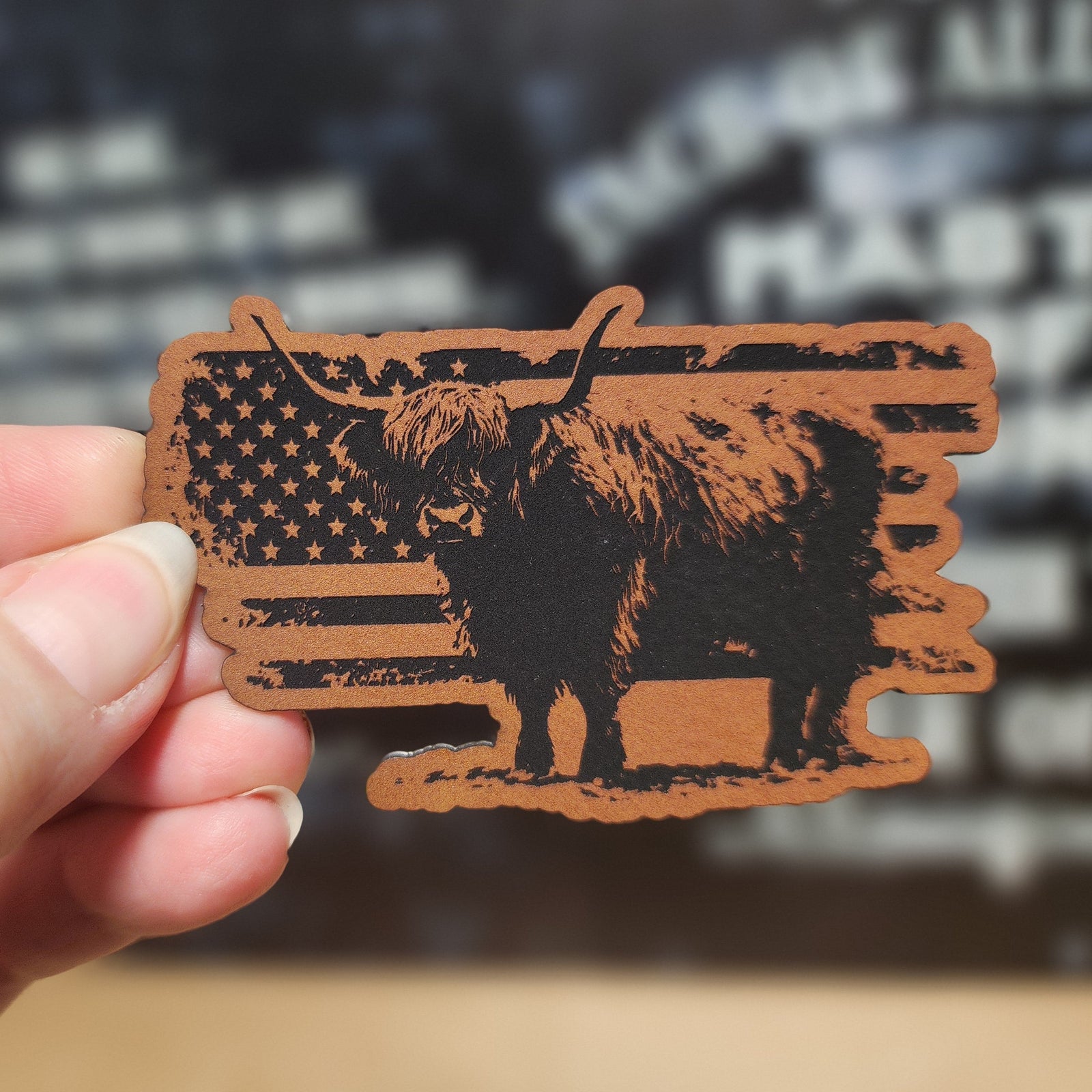 Highland cow leatherette hat patch with American flag design, perfect for Western wear enthusiasts and collectors.