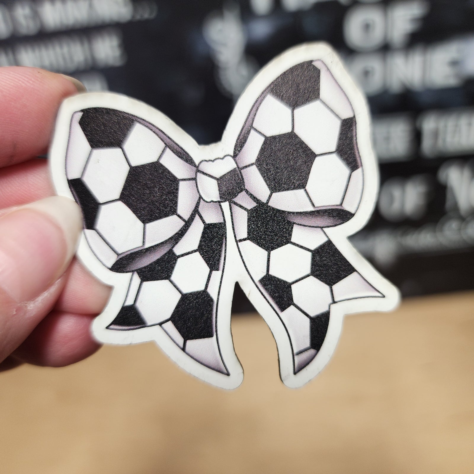 Soccer bow leatherette patch, perfect for sports fans and crafting enthusiasts, showcasing black and white soccer balls.