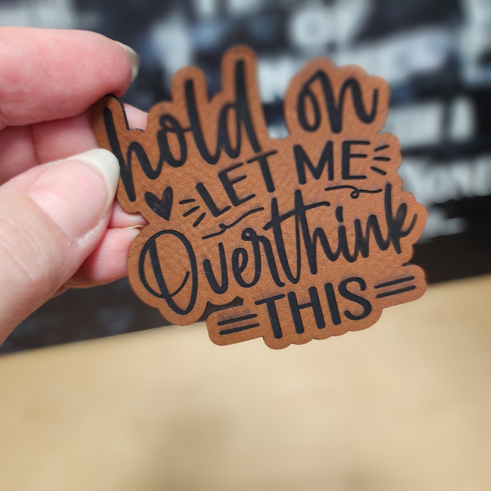 Leatherette hat patch with a humorous quote: 'Hold on, let me overthink this' for quirky fashion accessories.