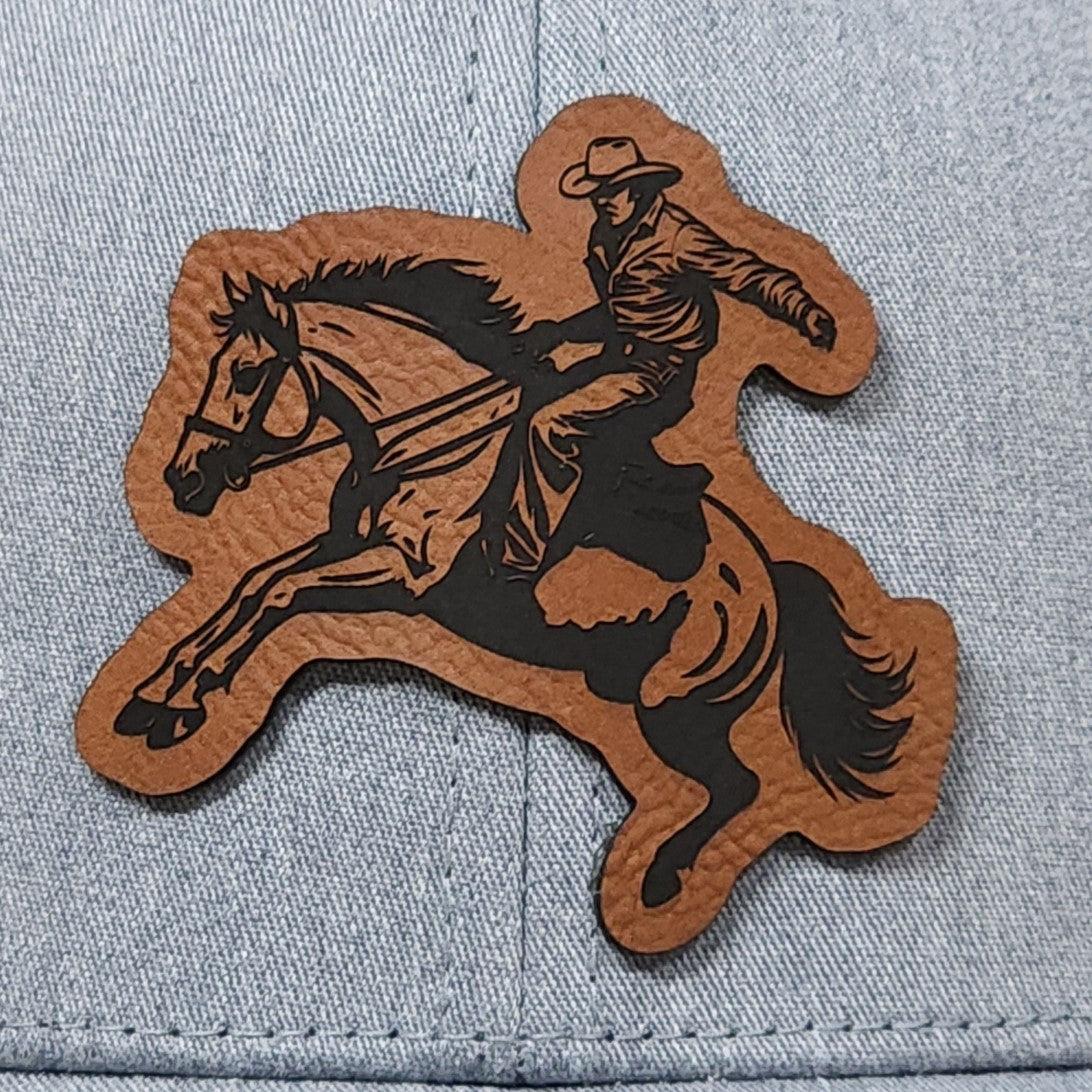 Western cowboy leatherette hat patch featuring a rider on a galloping horse for equestrian enthusiasts.