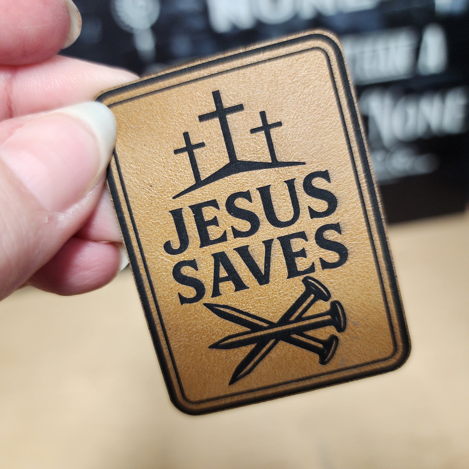 Jesus Saves leatherette hat patch with crosses and nails, perfect for faith-based apparel and accessories.