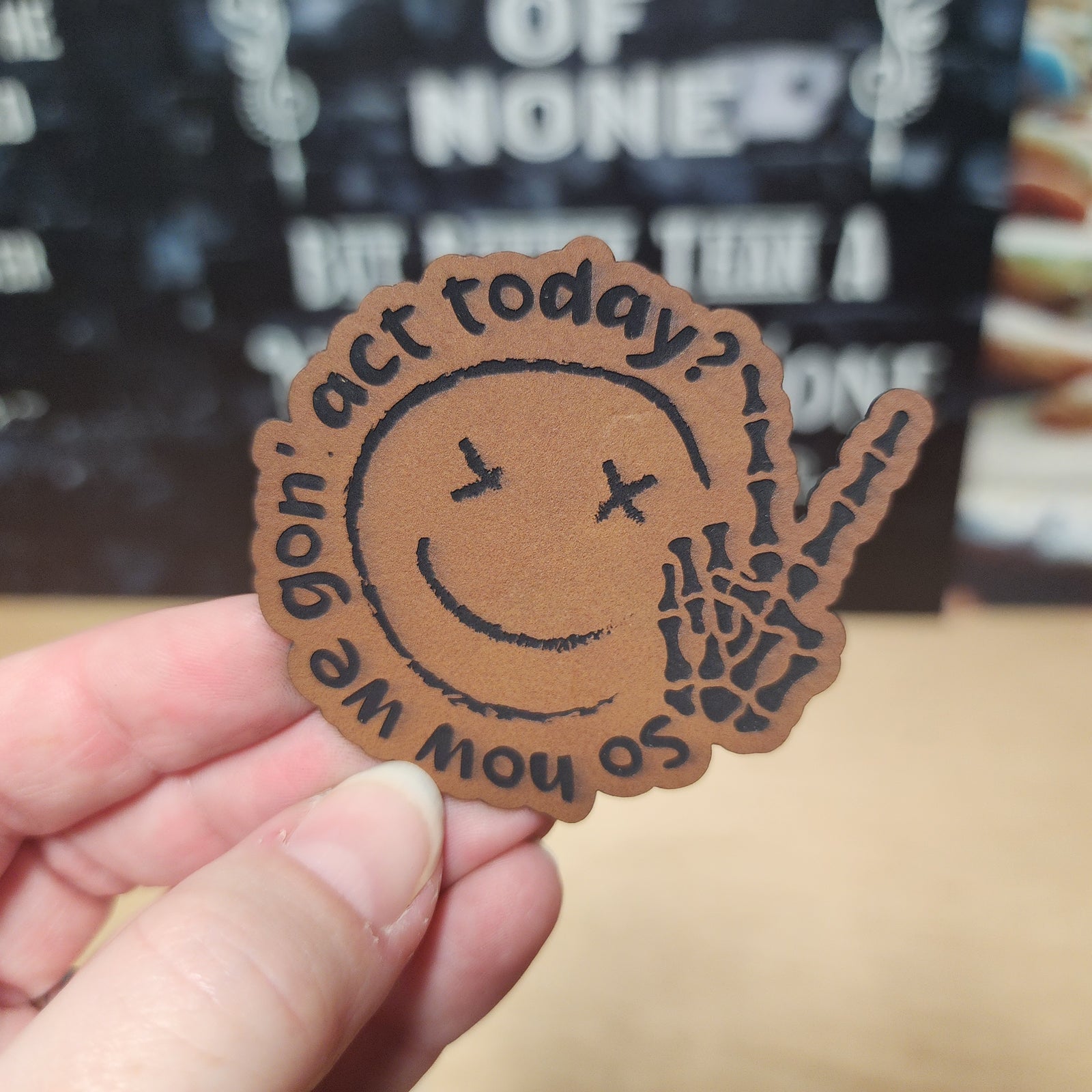 Leatherette hat patch with a playful skeleton peace sign and the phrase 'We gon' act today?' perfect for quirky outfits.