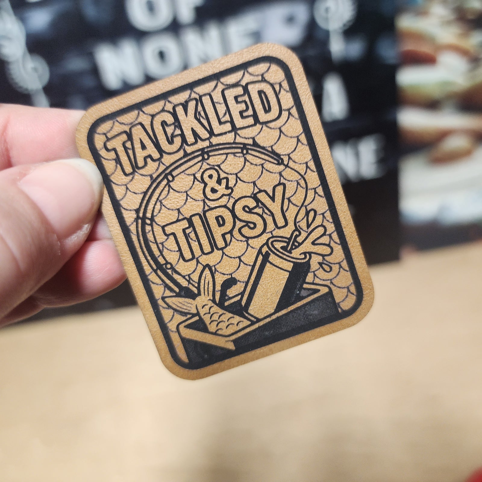 Tackled & Tipsy leatherette hat patch featuring fish and cocktail design, perfect for fishing enthusiasts.