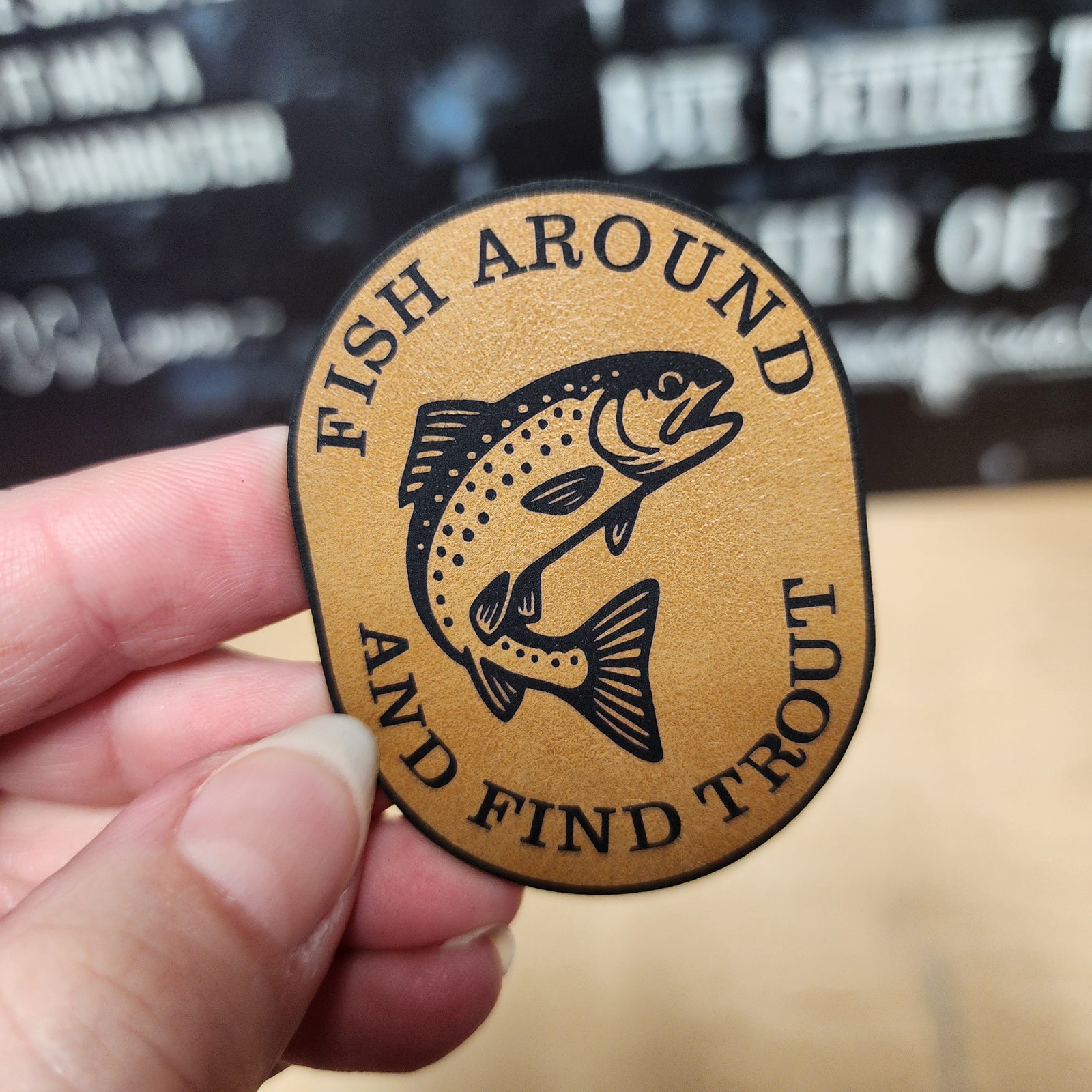 Fish Around and Find Trout leatherette hat patch for fishing enthusiasts and outdoor apparel.