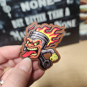Fiery piston cartoon leatherette hat patch for car enthusiasts and hot rod lovers. Bold automotive accessory.