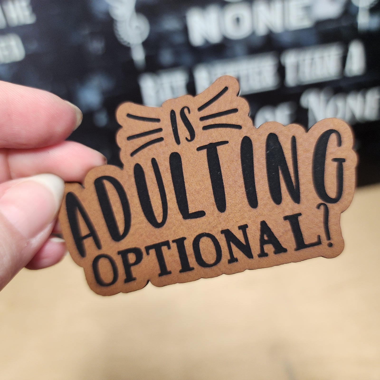 Humorous leatherette patch that says 'Is Adulting Optional?' perfect for hats or backpacks.
