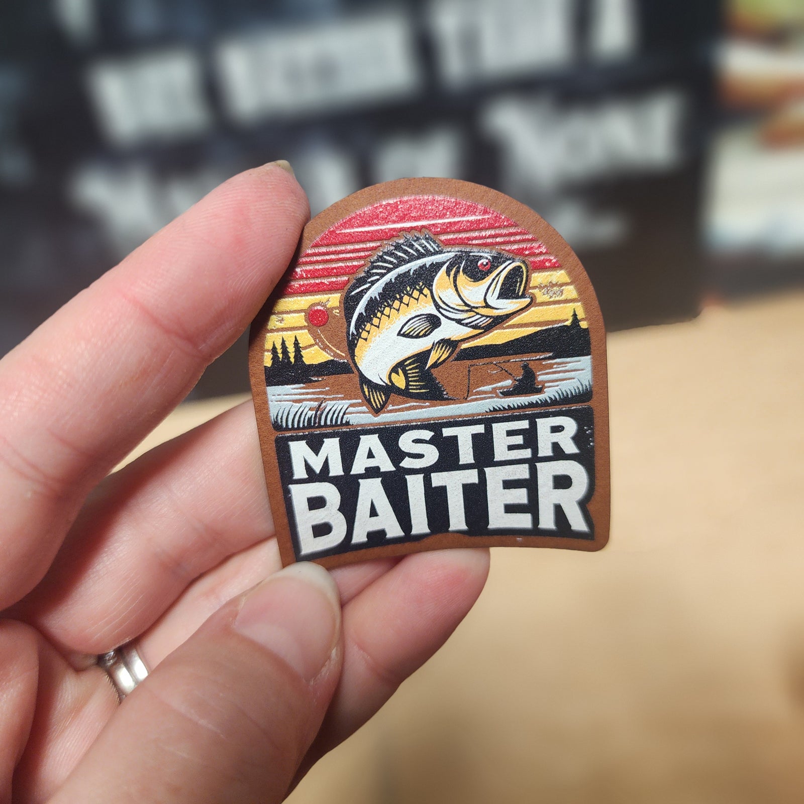 Master Baiter leatherette hat patch featuring a bass fish and vibrant sunset design, perfect for fishing enthusiasts.