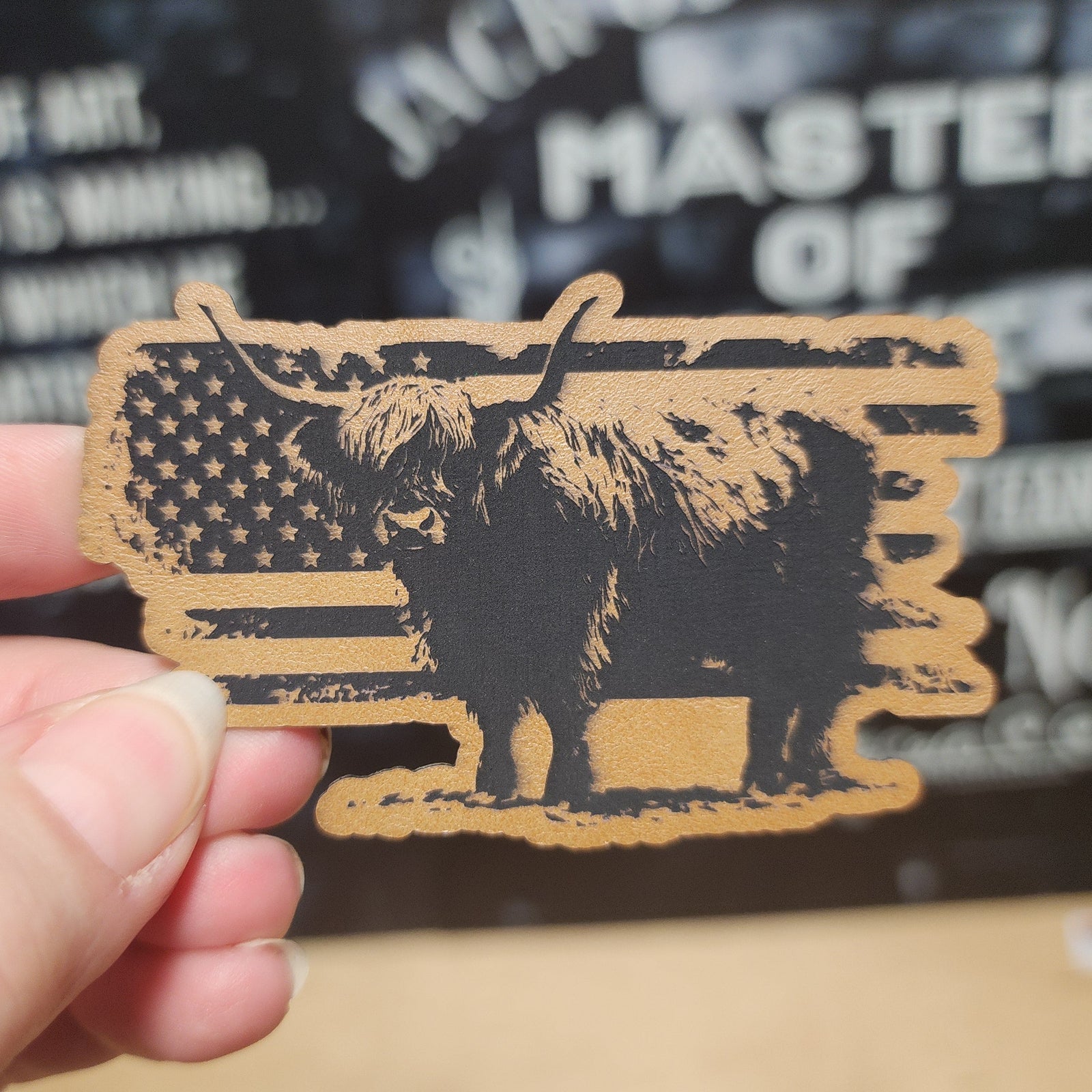 Highland cow leatherette hat patch with American flag design, rustic western decor for hats and apparel.
