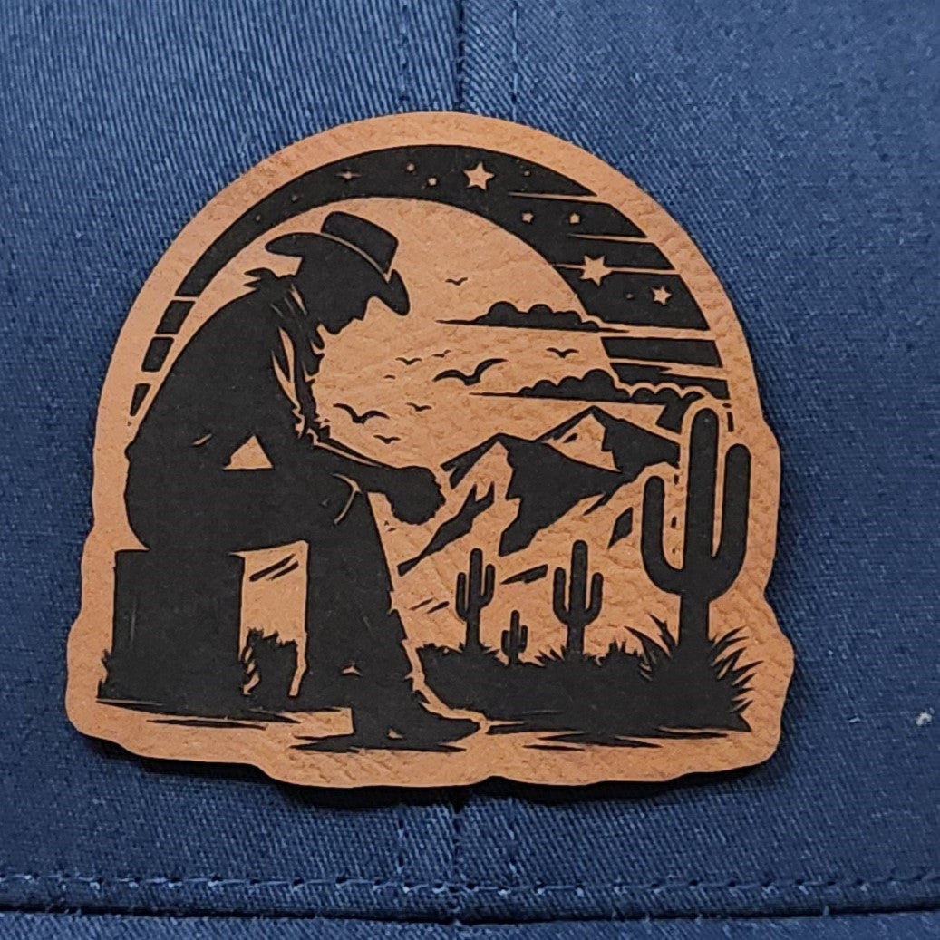 Western cowboy leatherette hat patch with mountains and cacti, perfect for outdoor enthusiasts and cowboy lovers.