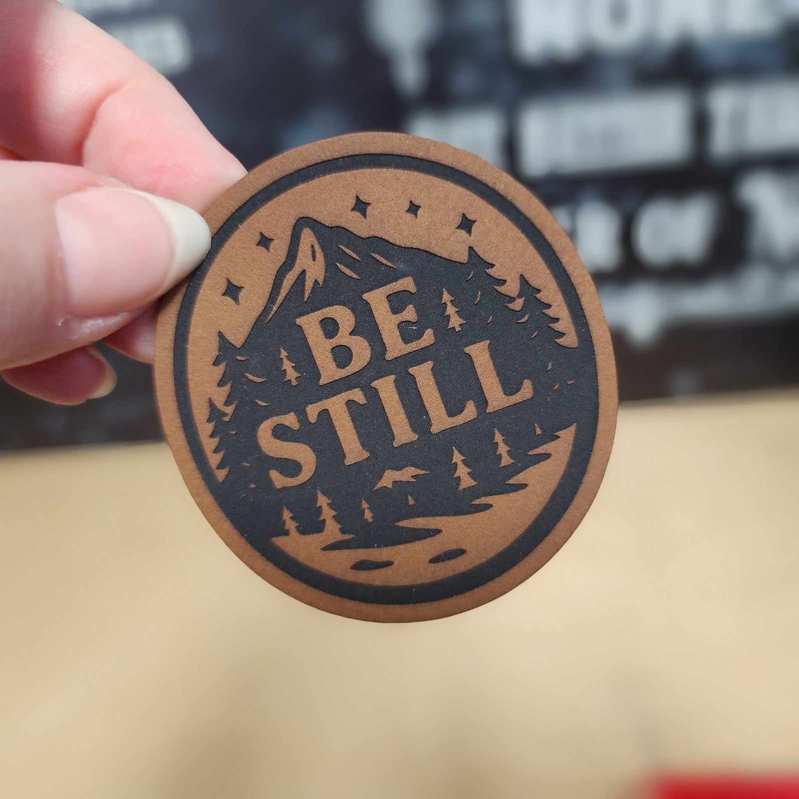 Be Still leatherette hat patch with mountain and forest design for outdoor enthusiasts and adventure lovers.