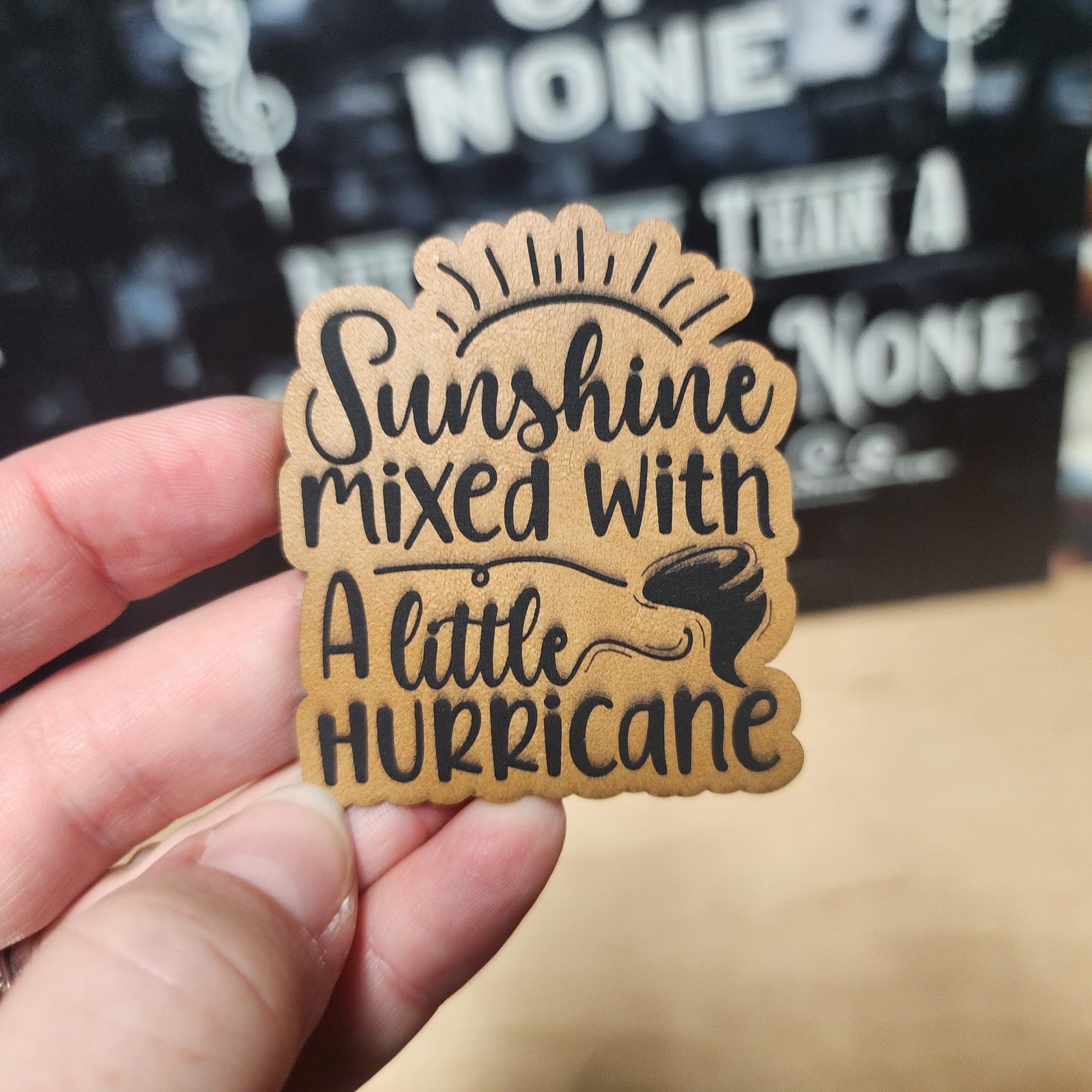 Leatherette hat patch featuring 'Sunshine mixed with a little Hurricane' design, perfect for trendy headwear.