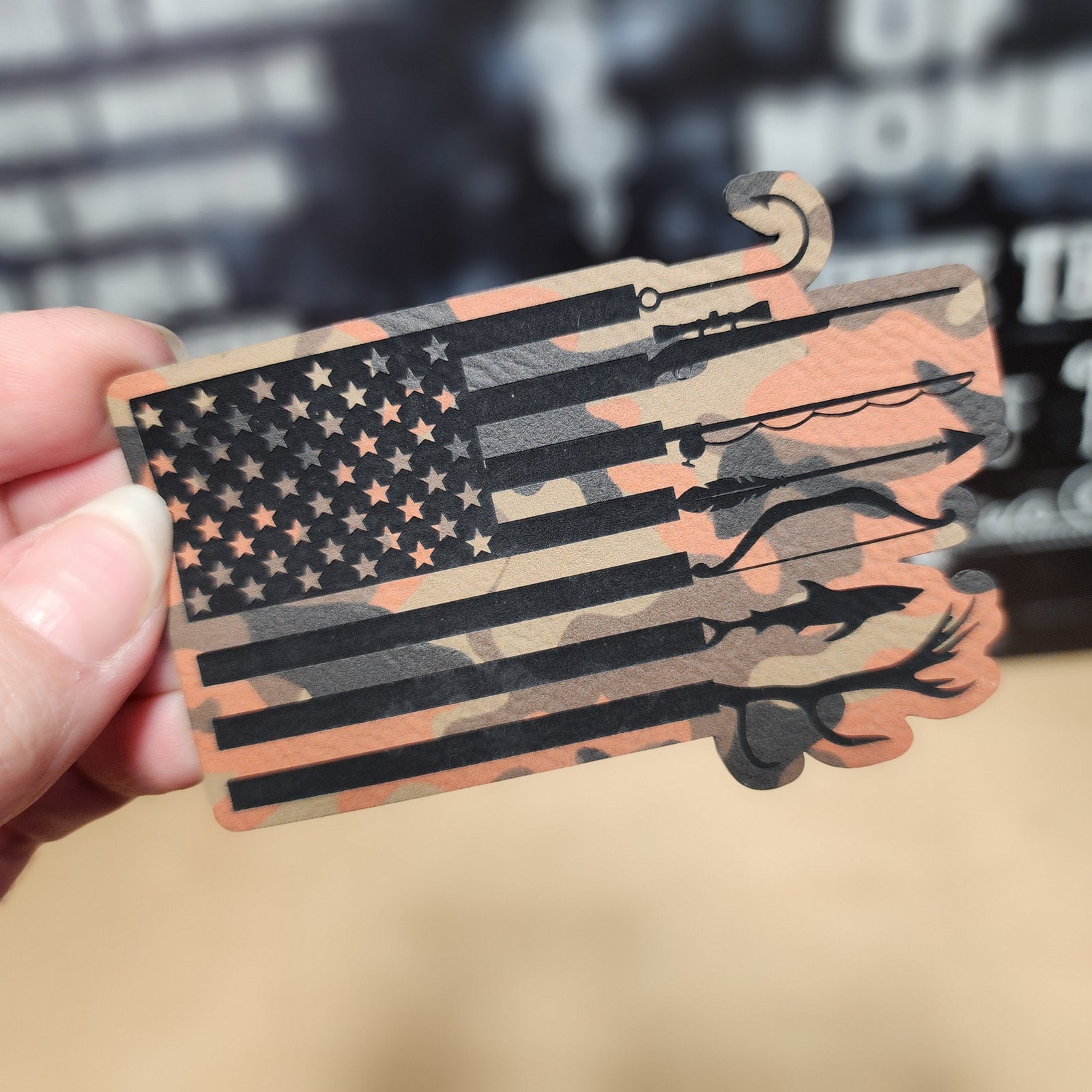 Patriotic camouflage leatherette hat patch featuring American flag and fishing gear designs for outdoor enthusiasts.