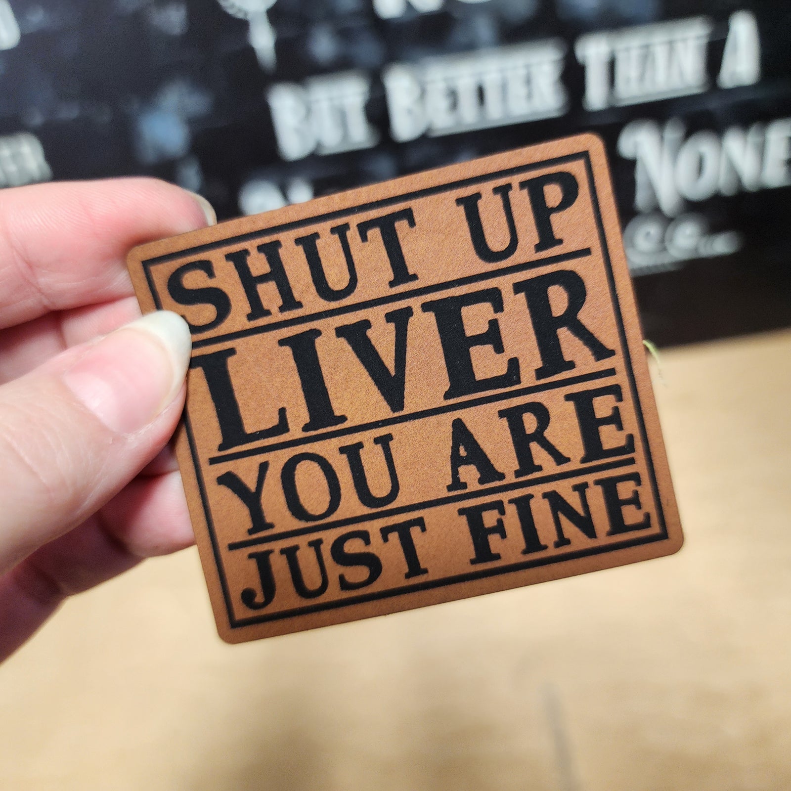 Funny leatherette hat patch that reads 'Shut Up Liver You Are Just Fine', perfect for quirky headwear.