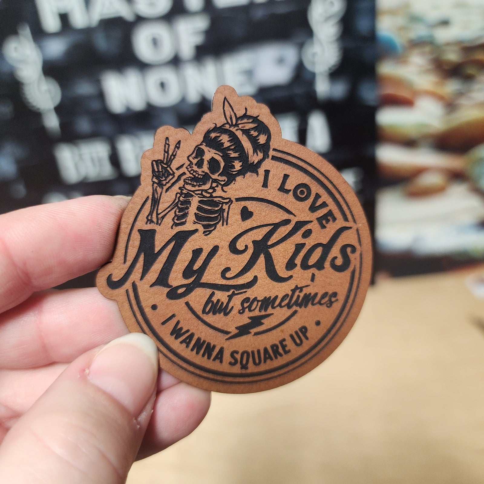 Unique leatherette hat patch featuring a humorous skeleton design with 'I love my kids but sometimes I wanna square up'.