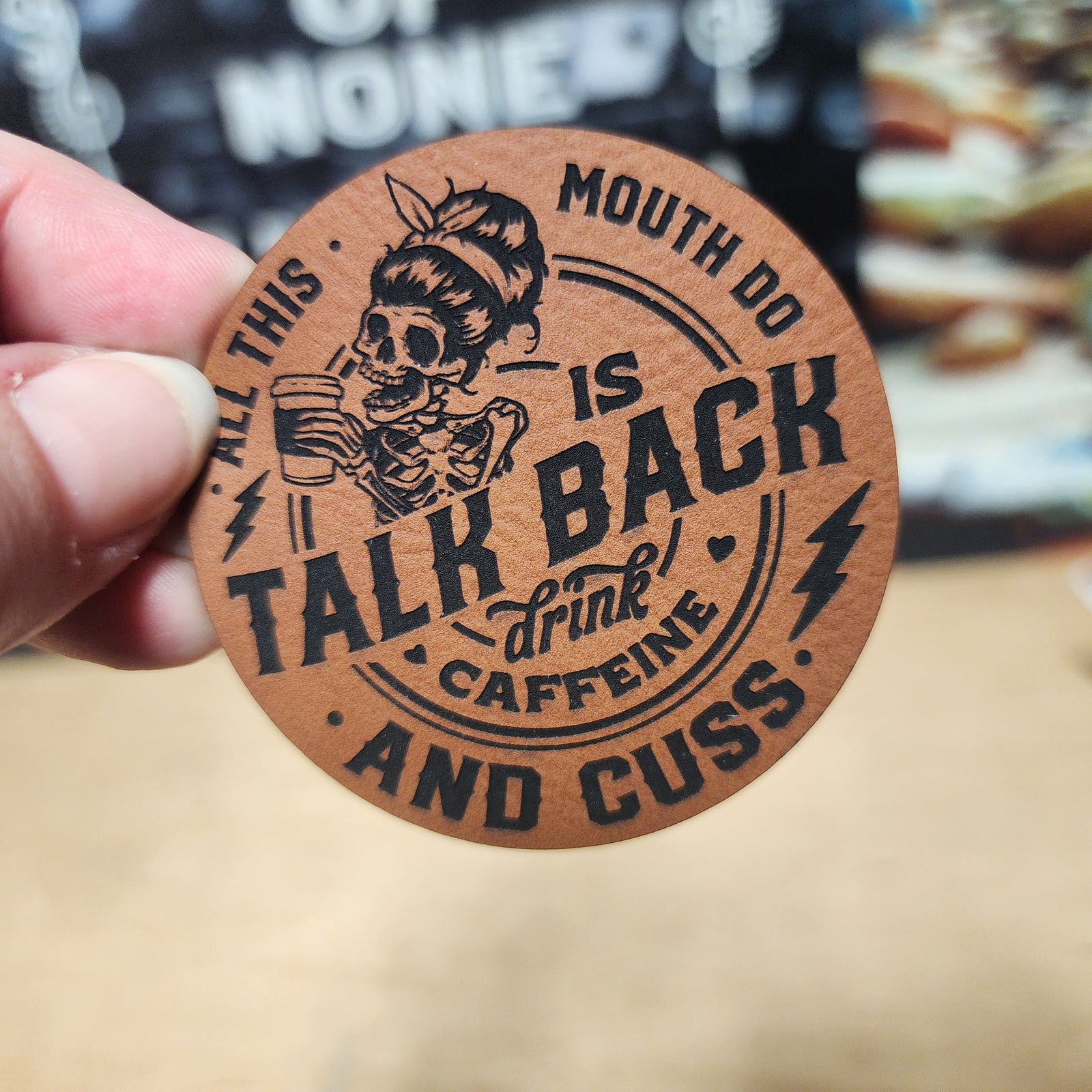 Funny leatherette hat patch featuring a skeleton girl with coffee, saying 'Talk Back, Drink Caffeine, and Cuss'.