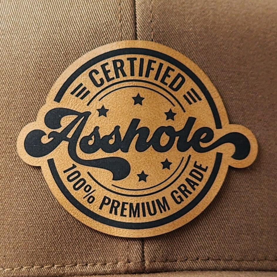 Funny leatherette hat patch with 'Certified Asshole' design for humor-loving cap enthusiasts.