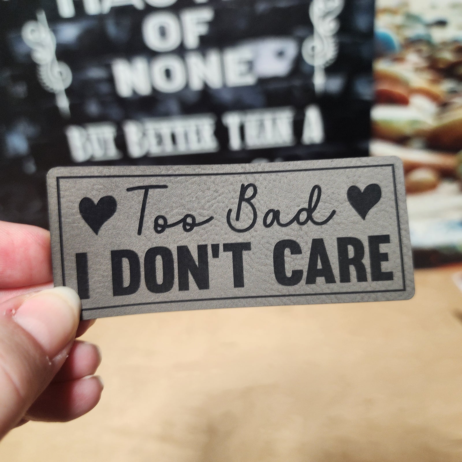 Leatherette hat patch reading 'Too Bad I Don't Care' for a sassy accessory, perfect for hats and bags.