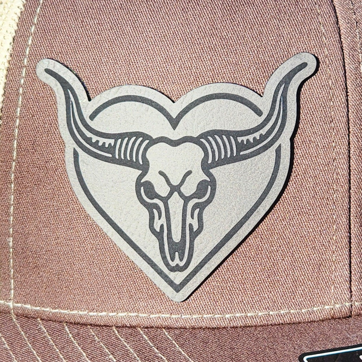 Western leatherette hat patch featuring a bull skull in a heart, perfect for cowboy hats and rustic style.