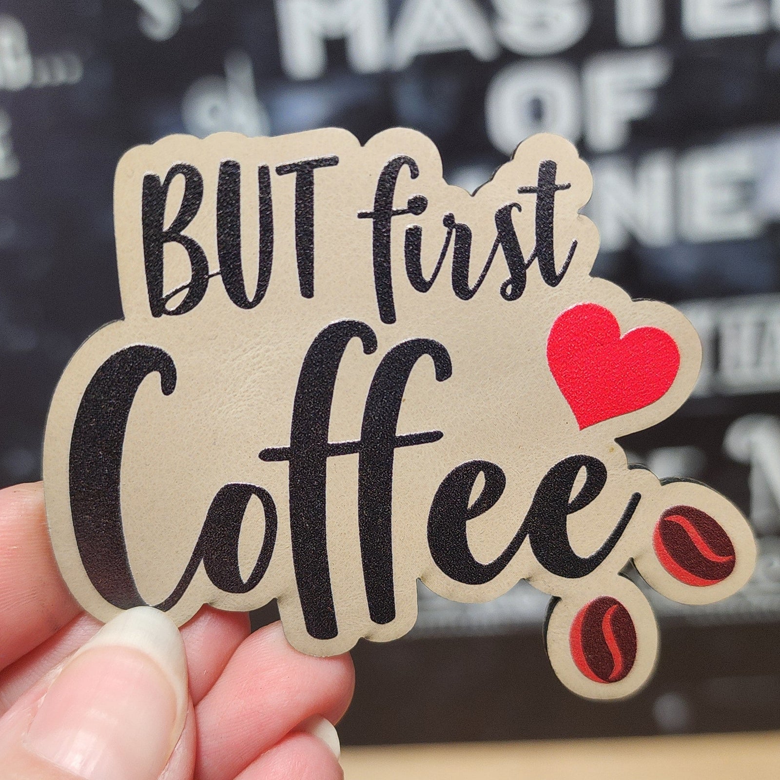 Coffee lovers leatherette patch, perfect for hats, featuring 'But first Coffee' design with coffee beans.