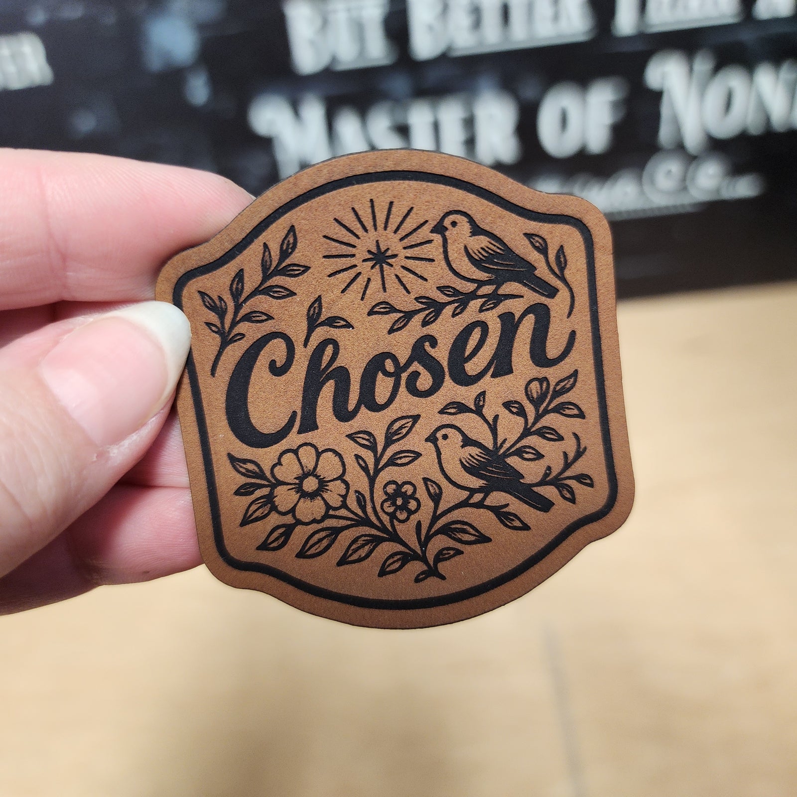 Chosen leatherette hat patch with floral design and birds, perfect for personalizing hats or bags.