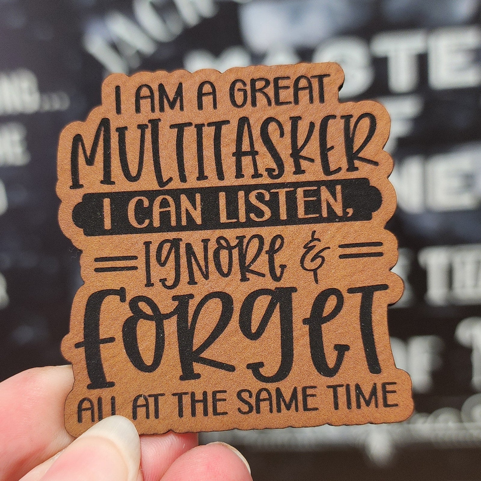 Funny leatherette hat patch featuring multitasking quote: 'I can listen, ignore & forget all at the same time'.