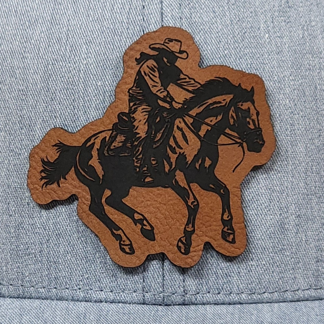 Cowboy riding horse leatherette hat patch perfect for Western apparel and cowboy enthusiasts.