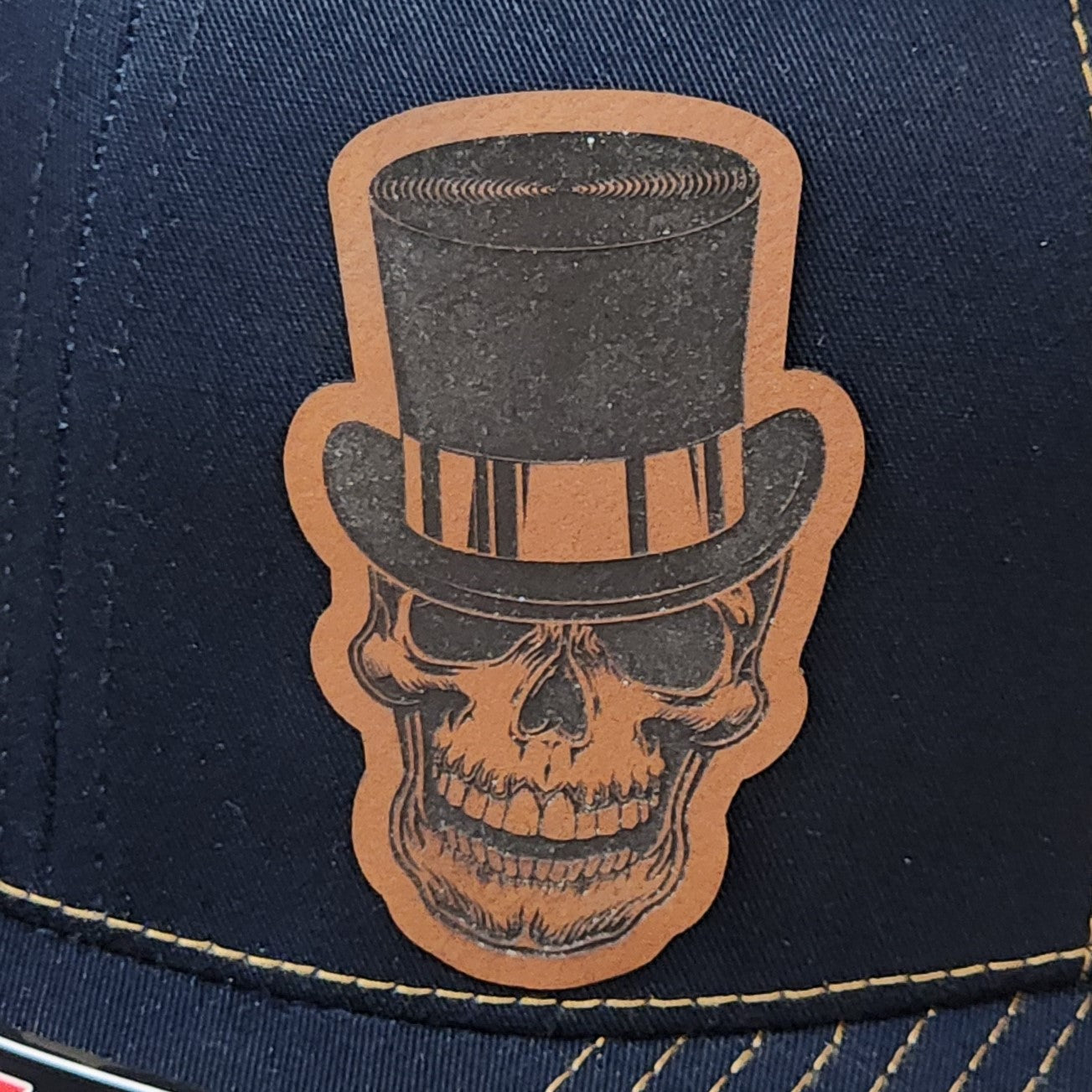 Stylish leatherette hat patch featuring a top hat skull design, perfect for Halloween or gothic fashion lovers.
