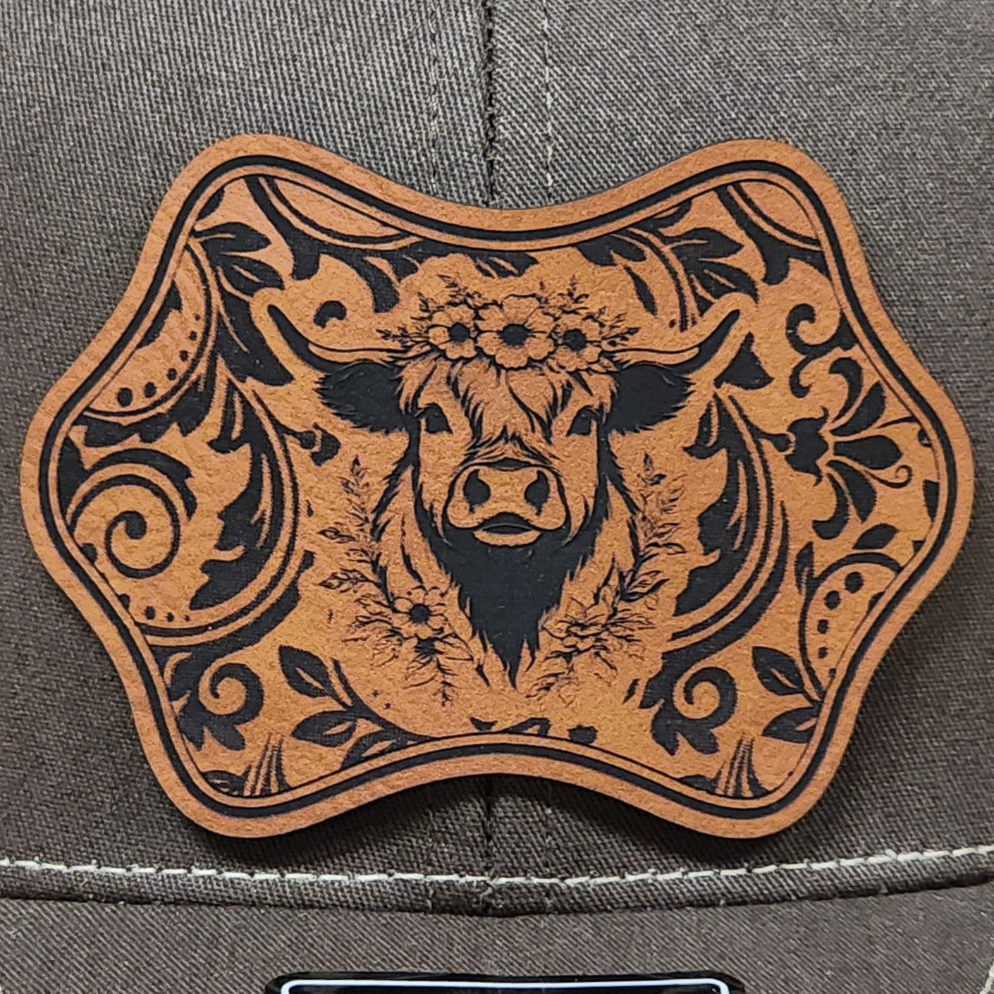 Cowgirl leatherette hat patch with floral design and cow illustration, perfect for western-themed apparel.