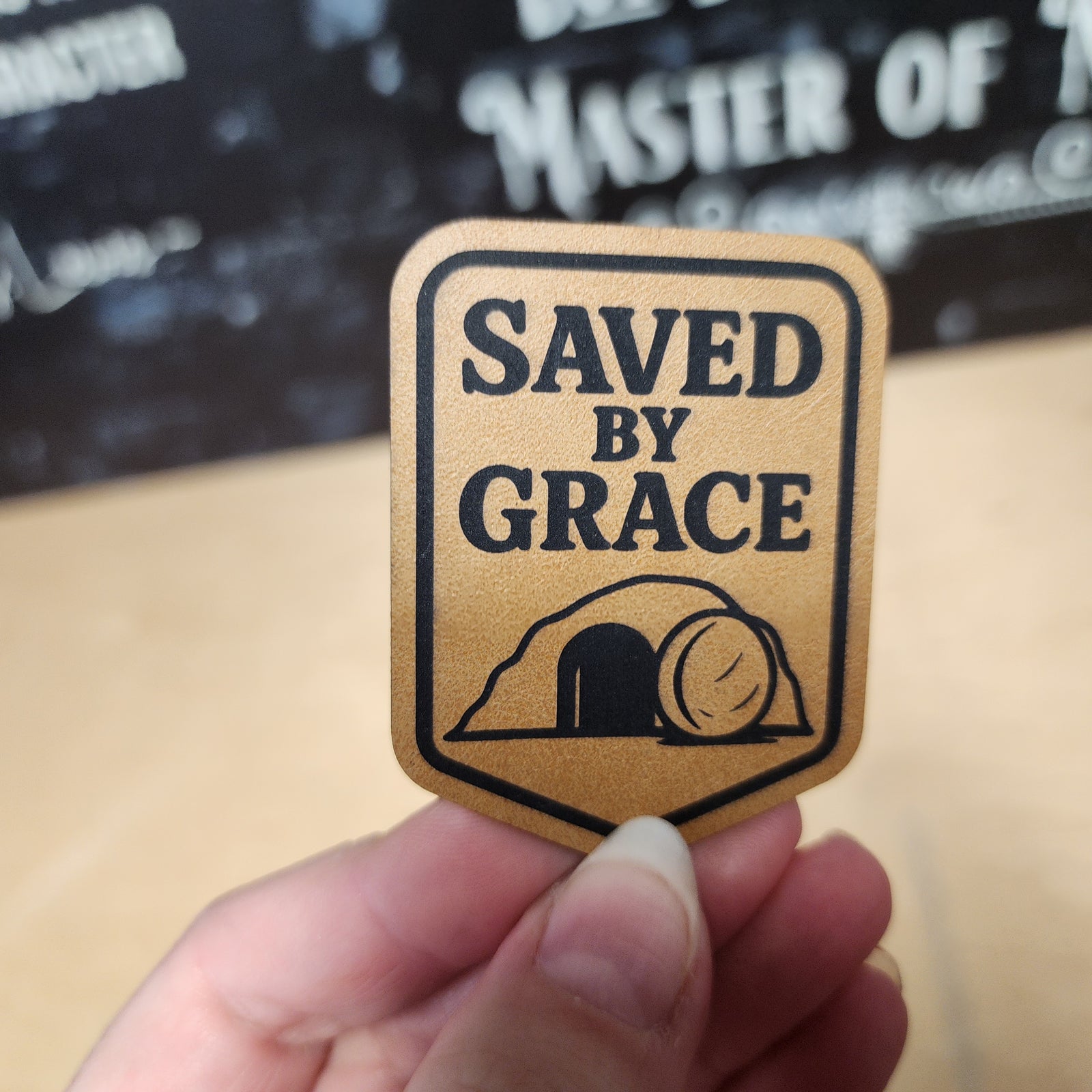 Saved by Grace leatherette hat patch featuring a tomb design, perfect for faith-inspired accessories and gifts.