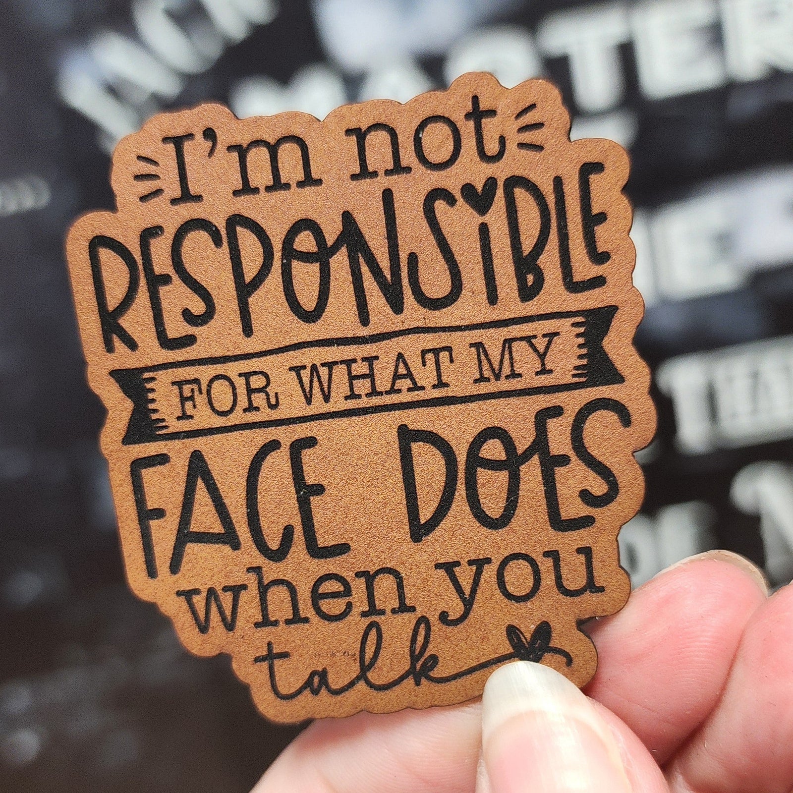 Leatherette humor hat patch saying 'I'm not responsible for what my face does when you talk,' perfect for quirky gifts.